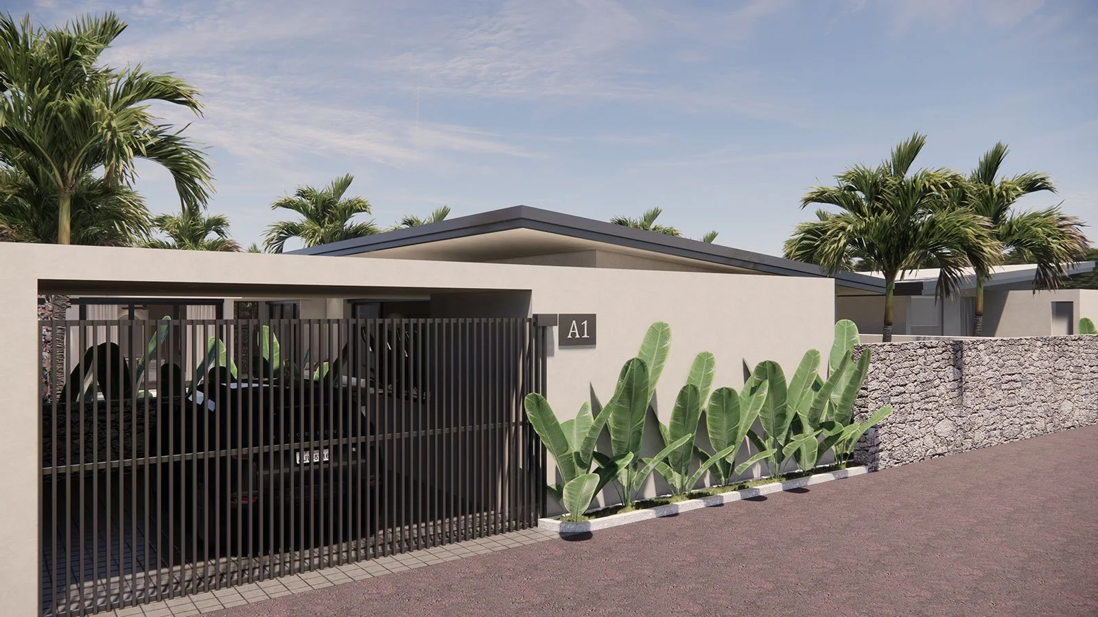 Modern residential building with a black metal gate, tropical plants, a stone wall, and palm trees under a partly cloudy sky.