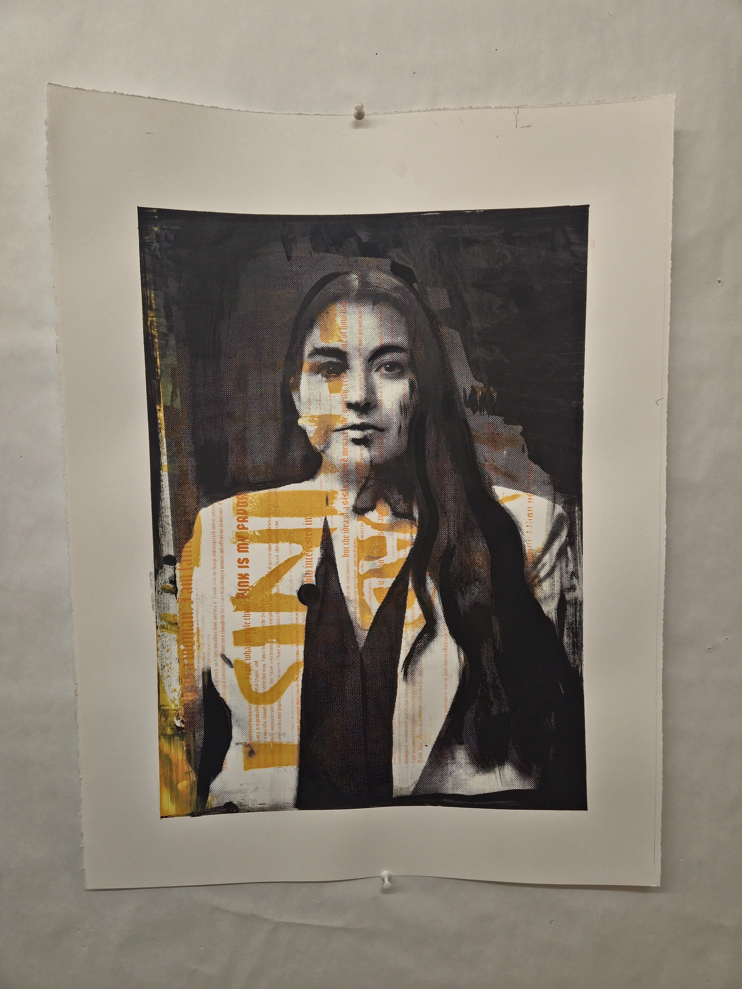 Mixed media artwork on paper featuring a woman's portrait with layers of printed text and yellow paint, mounted on a wall.