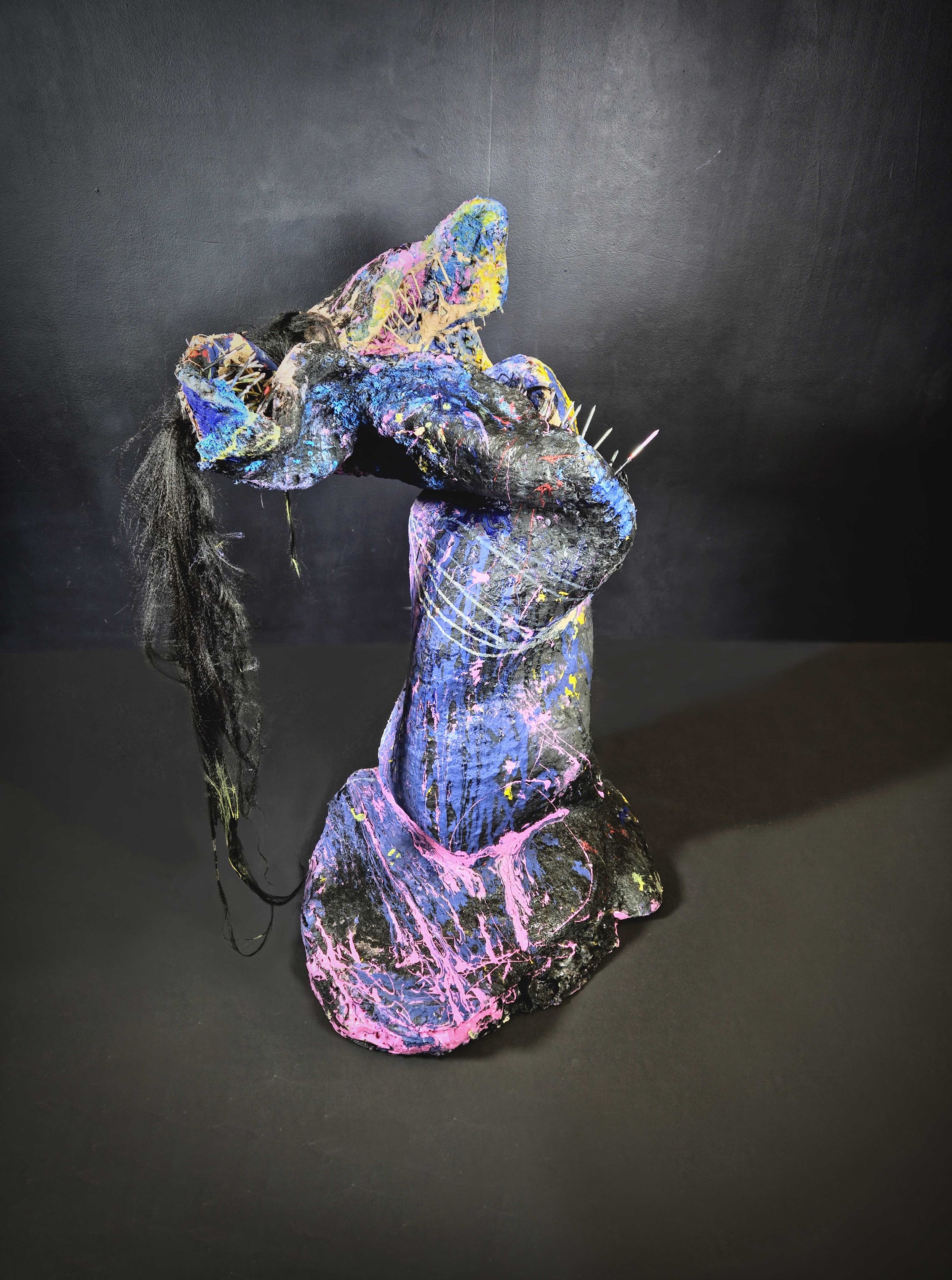 Colorful abstract sculpture of a horse against a black background.
