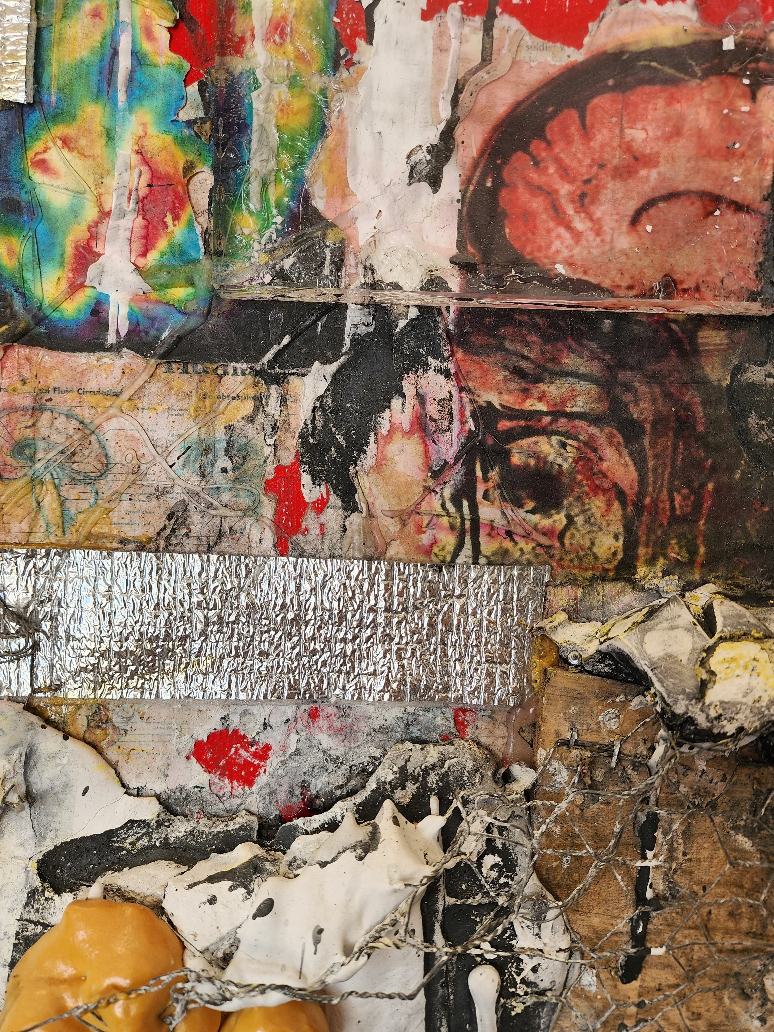 Abstract mixed media artwork with splashes of color, black and white paint, layered textures, a silver foil strip, and a chain-link fence element.