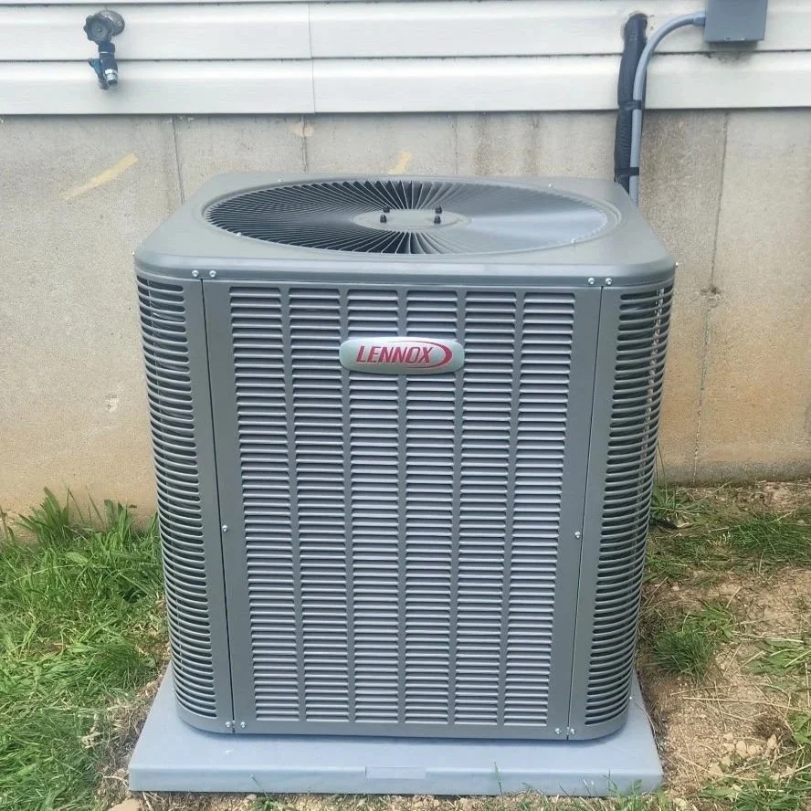 Lennox outdoor air conditioning unit outside a house, on a concrete pad.
