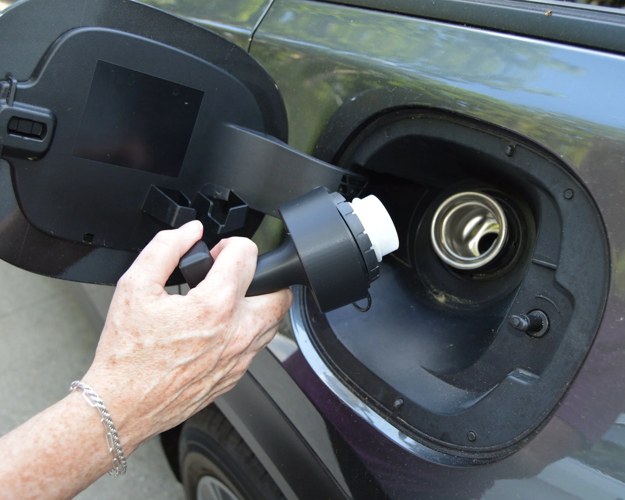 Person installing or repairing a windshield wiper on a dark-colored car.