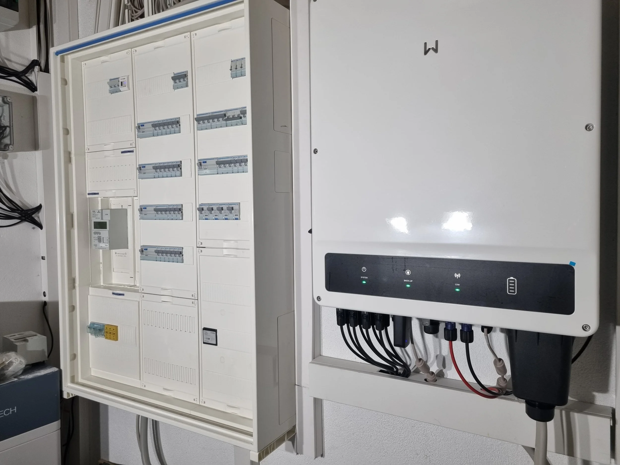 Elektrischer Schaltschrank mit offenen Türen, sichtbare Sicherungen, Schalter und Kabel, sowie eine Steuerungseinheit mit Anzeige und Bedienelementen.