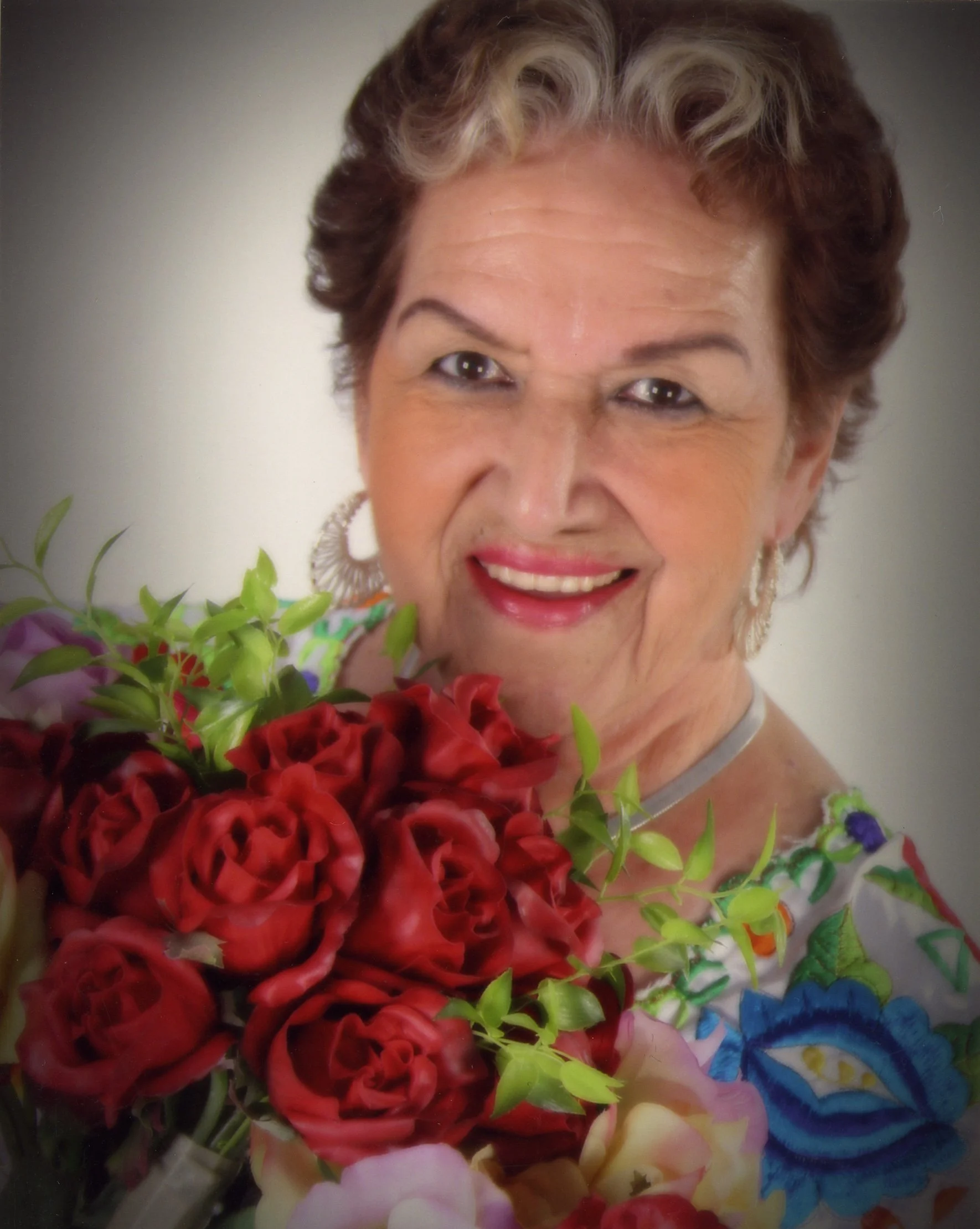 Rita Vidaurri with a bouquet of roses, Courtesy Esperanza Peace and Justice Center, San Antonio, Texas