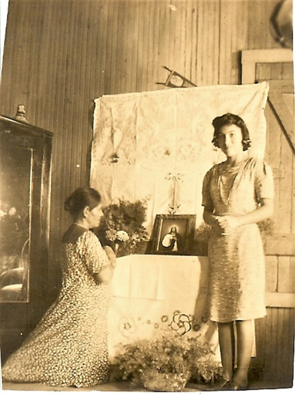 Sebastiana kneeling in prayer, her daughter Eduarda (Lala) Rodriguez Leija standing near, Laredo, Texas, 1940s, Courtesy of María Antonietta Berriozábal 