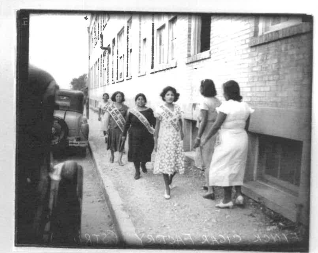 Striking workers picketing in front of plant. They are wearing banners calling for better working conditions, August 11, 1993