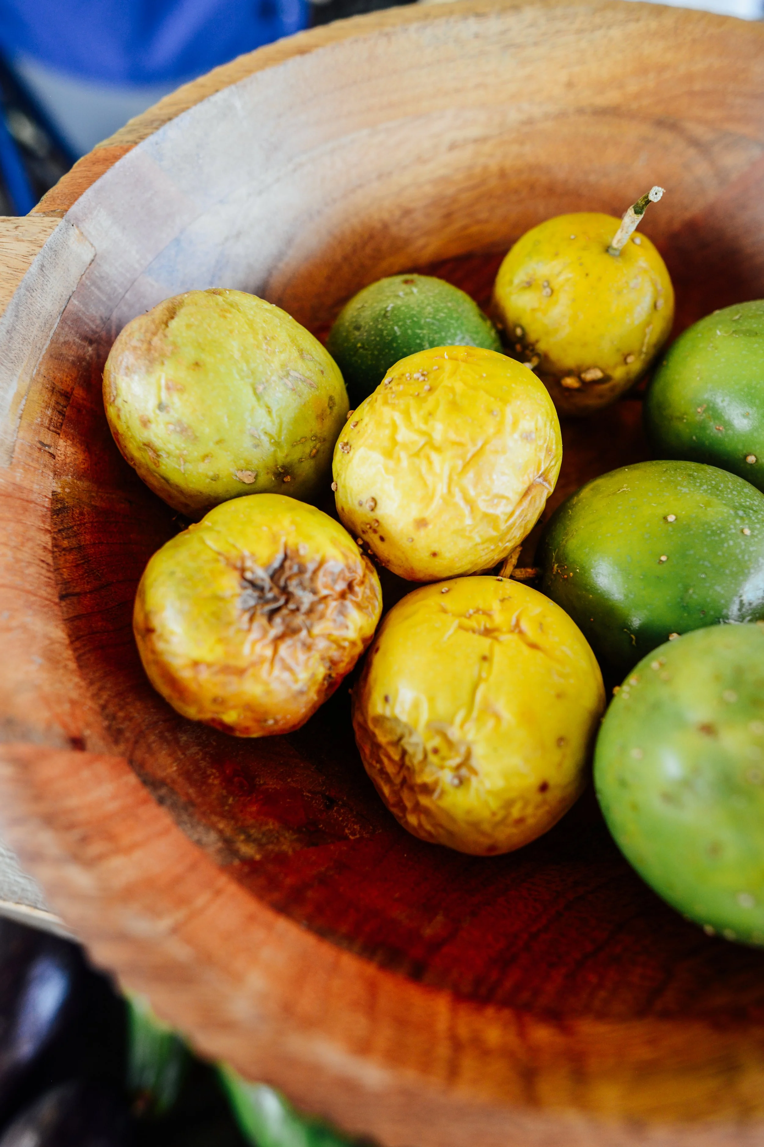 Close-up of green and yellow apples in a wooden bowl.