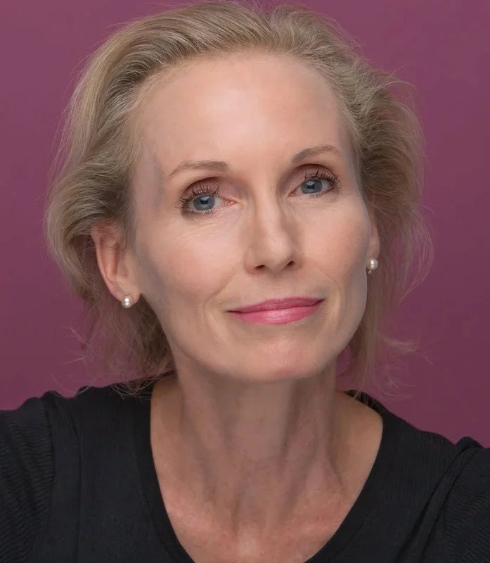 A portrait of a woman smiling at the camera.