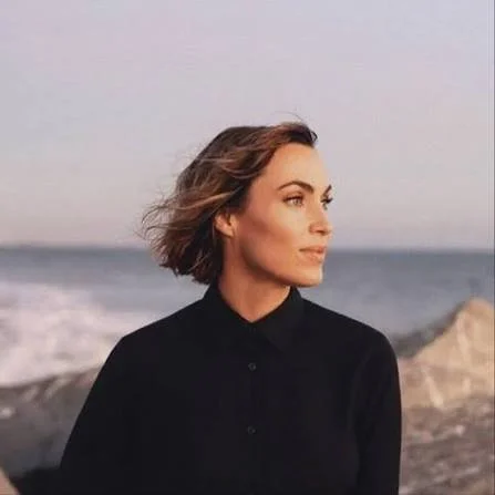 A portrait of a woman smiling at the camera.