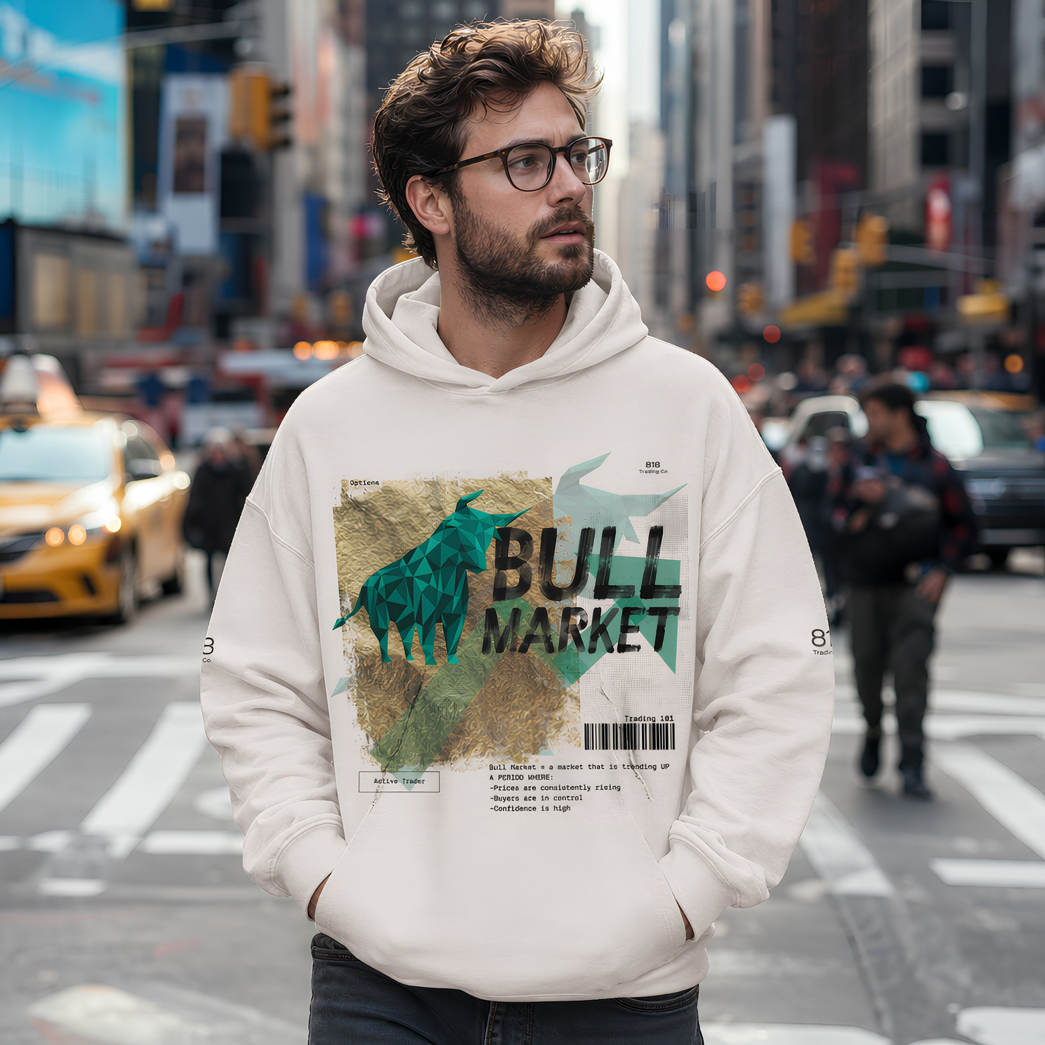 A man with glasses and a beard wearing a white hoodie with a graphic design on the front stands on a busy city street, with tall buildings, taxis, and pedestrians in the background.
