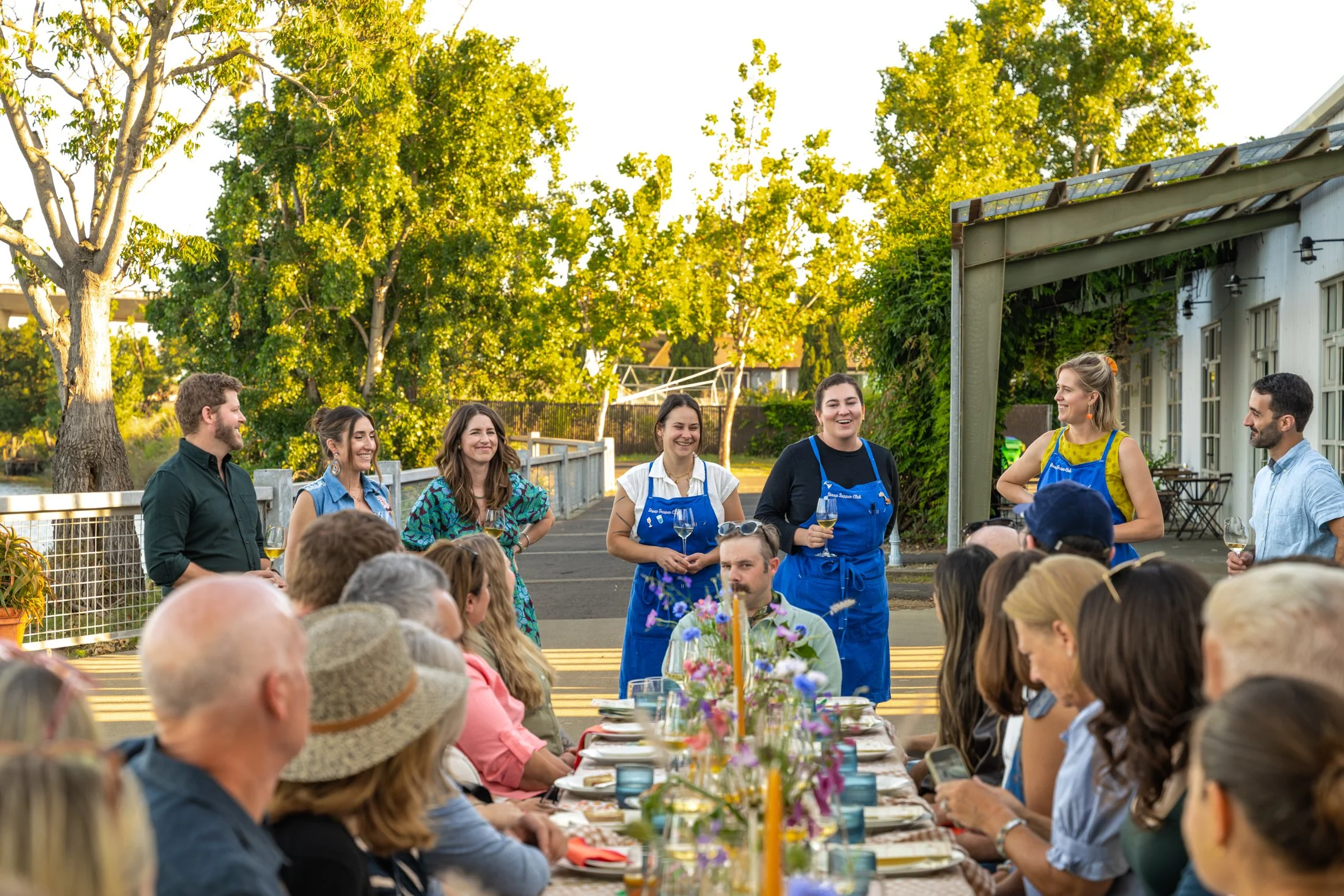 Guests dining together at a Stoop Supper Club dinner overlooking the Napa River at The River Club.