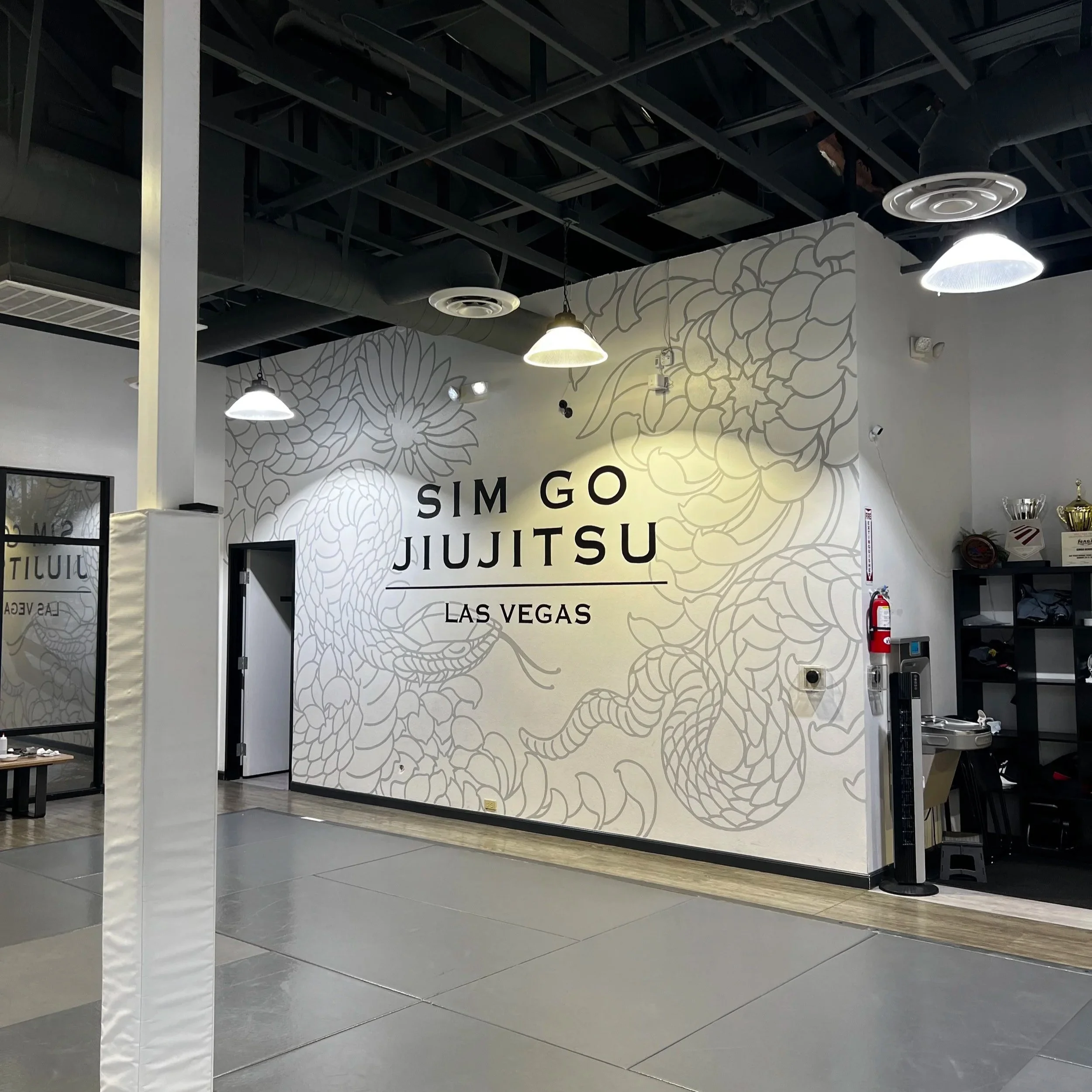 Wall mural at Sim Go Jiu Jitsu gym in Las Vegas with a dragon illustration and text.