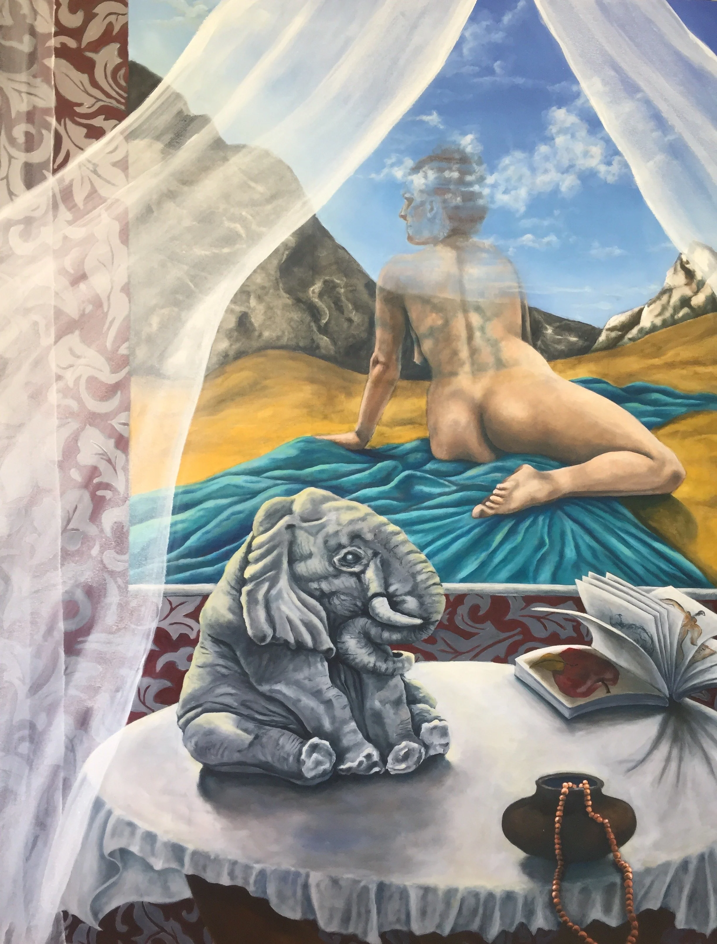 A wall mural of a woman with curly hair looking out a window at mountains and a blue sky. In front of the mural, there is a three-dimensional sculpture of an elephant on a table, with a skull and an open book with artwork inside. A brown jar with beads draped over it is also on the table.