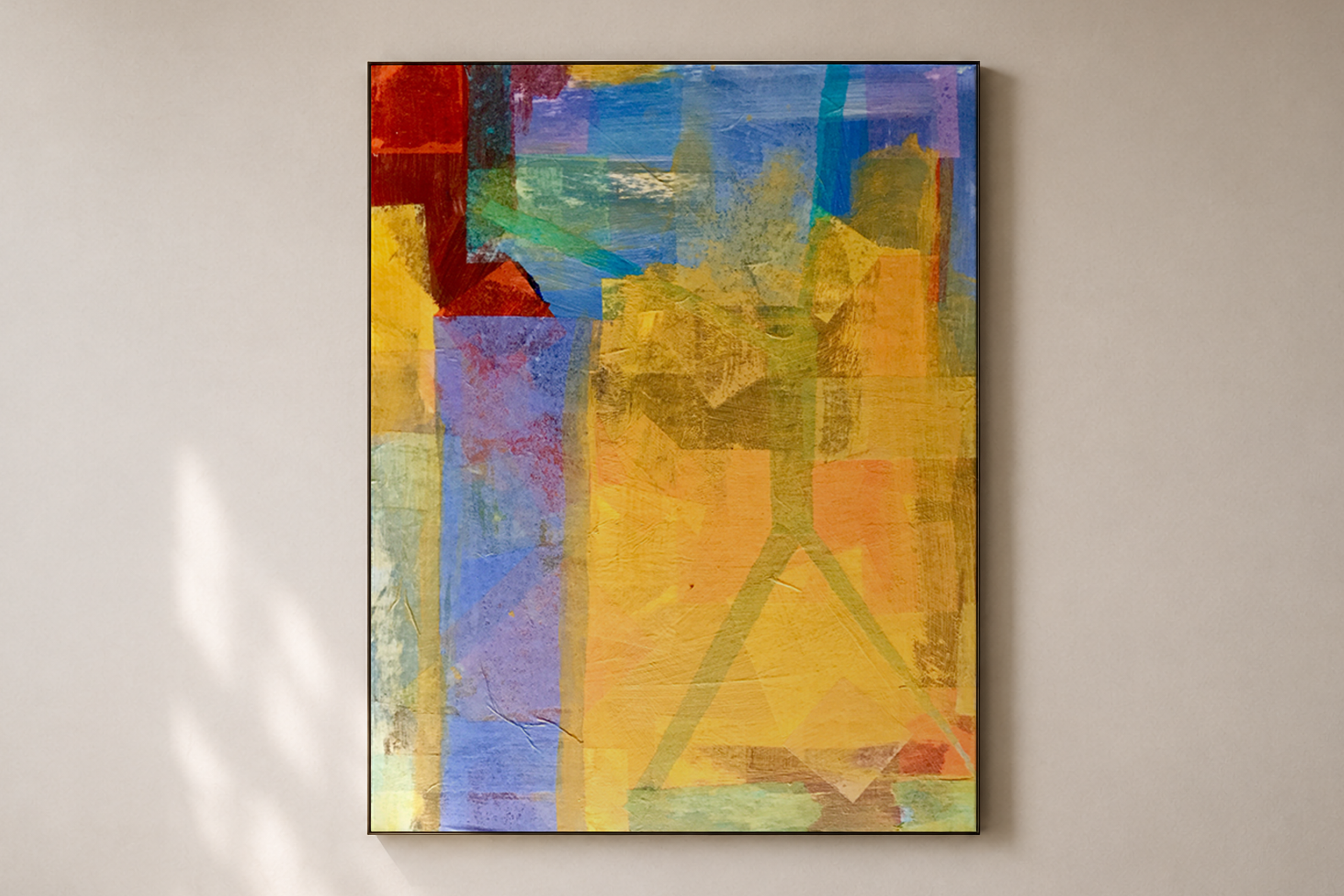 An abstract colorful painting with various shades of blue, yellow, red, green, and purple, framed and hung on a beige wall.