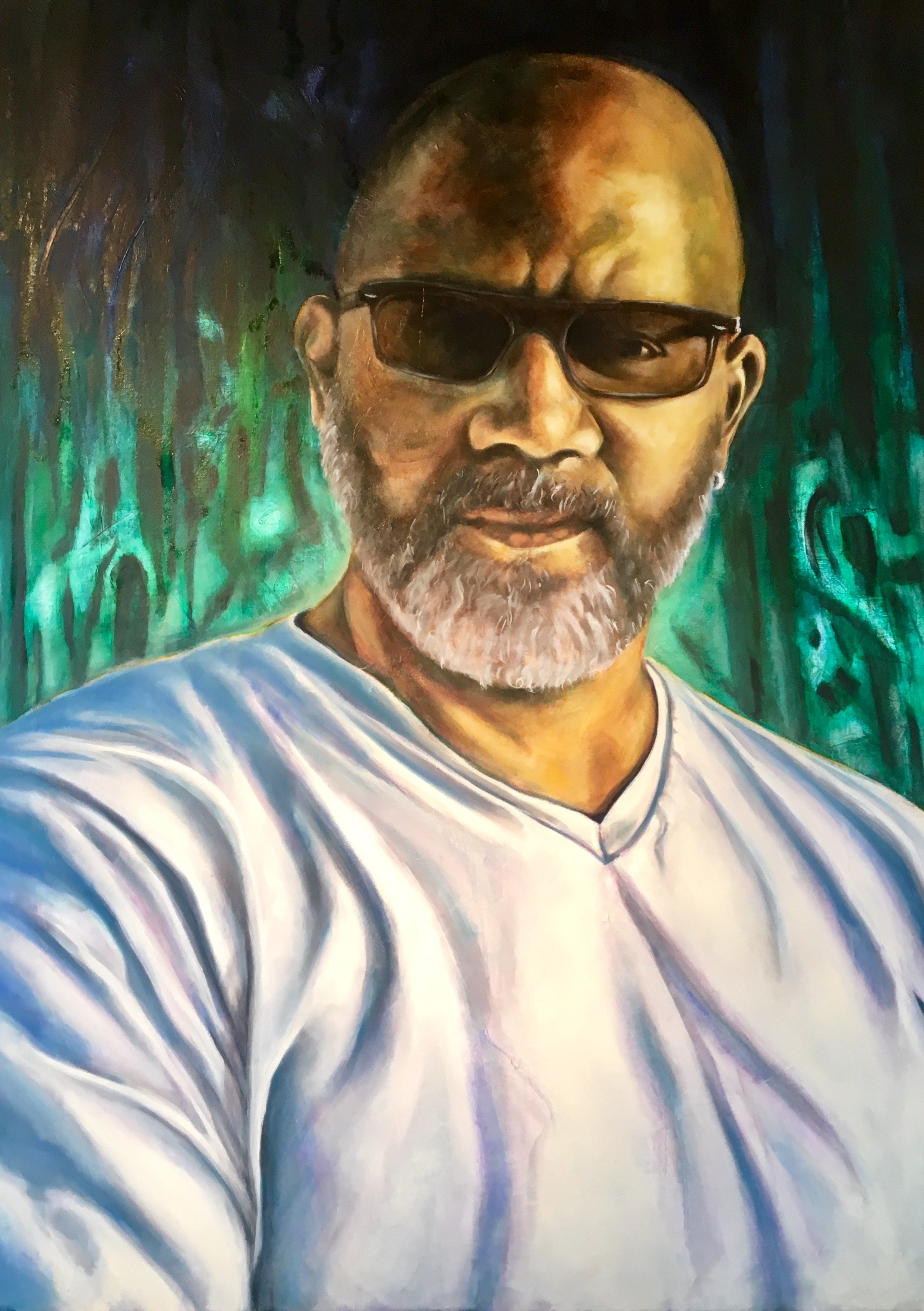 A portrait of a man with a bald head, glasses, and a beard, wearing a white shirt with blue stripes, set against a green and blue abstract background.