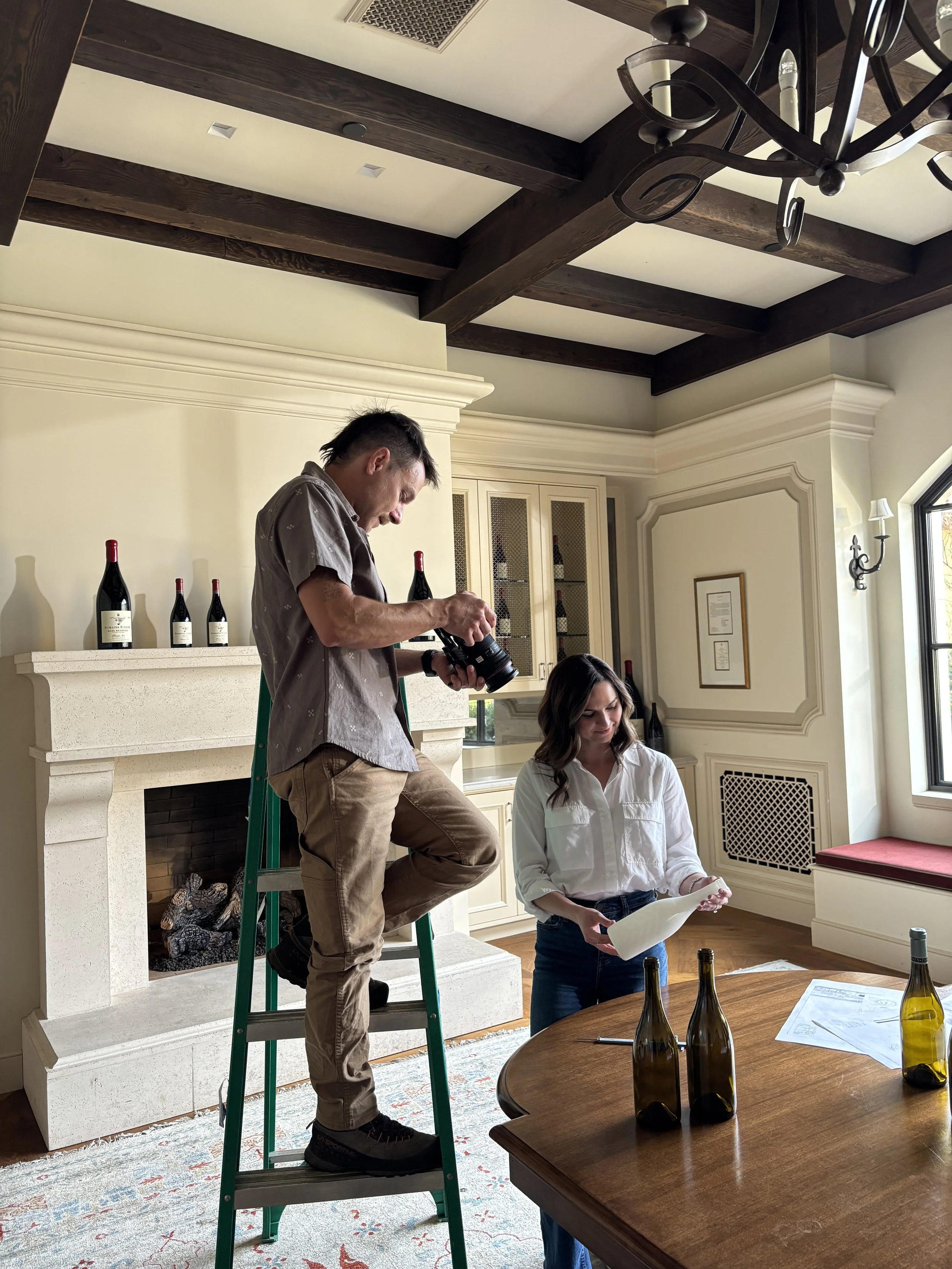 Behind the scenes image of California based director and photographer Kaare Iverson shooting from a ladder at Domaine Serene Winery outside Portland, Oregon