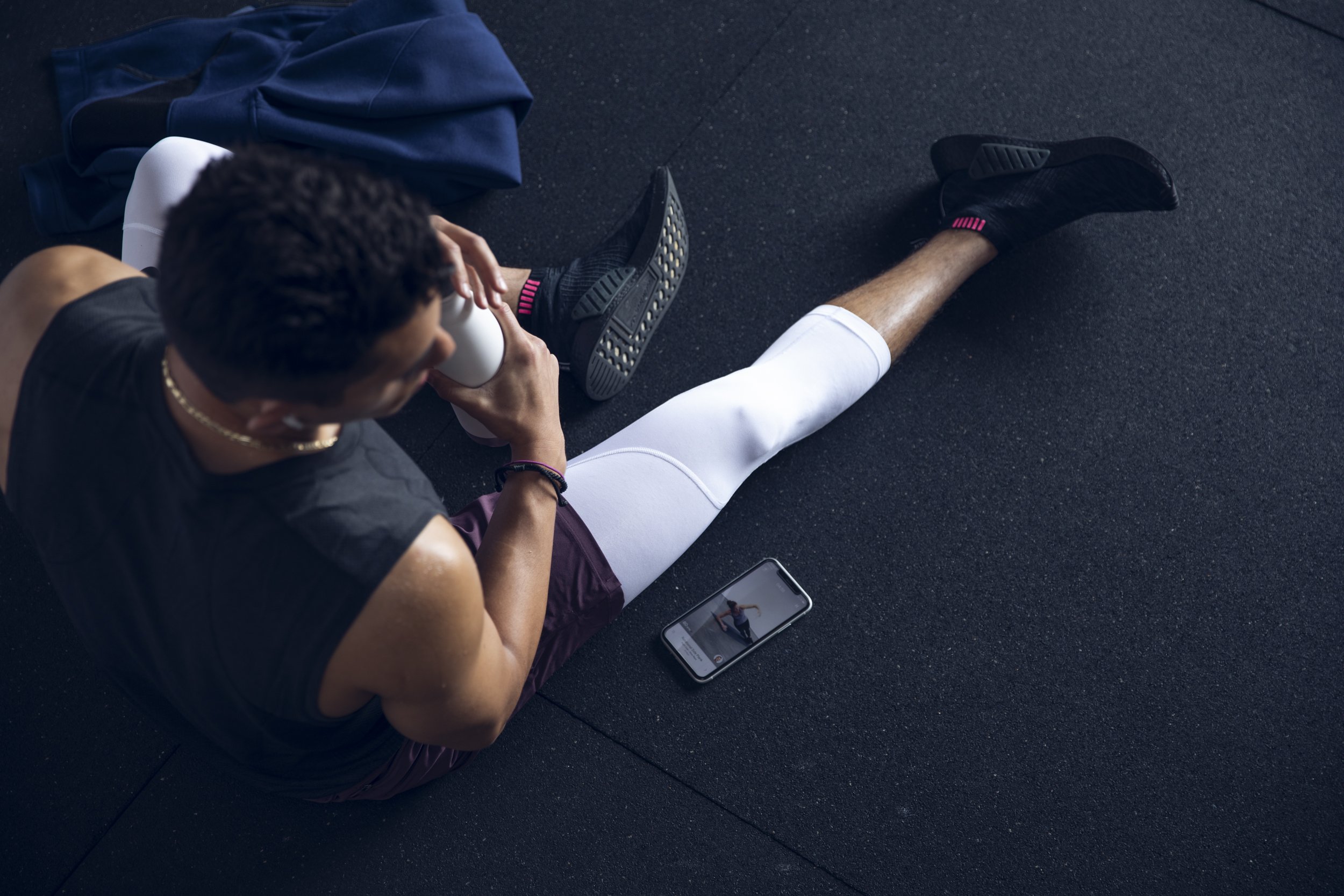 Fitness lifestyle photography by Bay Area commercial photographer Kaare Iverson. A man resting after a workout and reviewing his smartphone app. Shot for Future Fit App.
