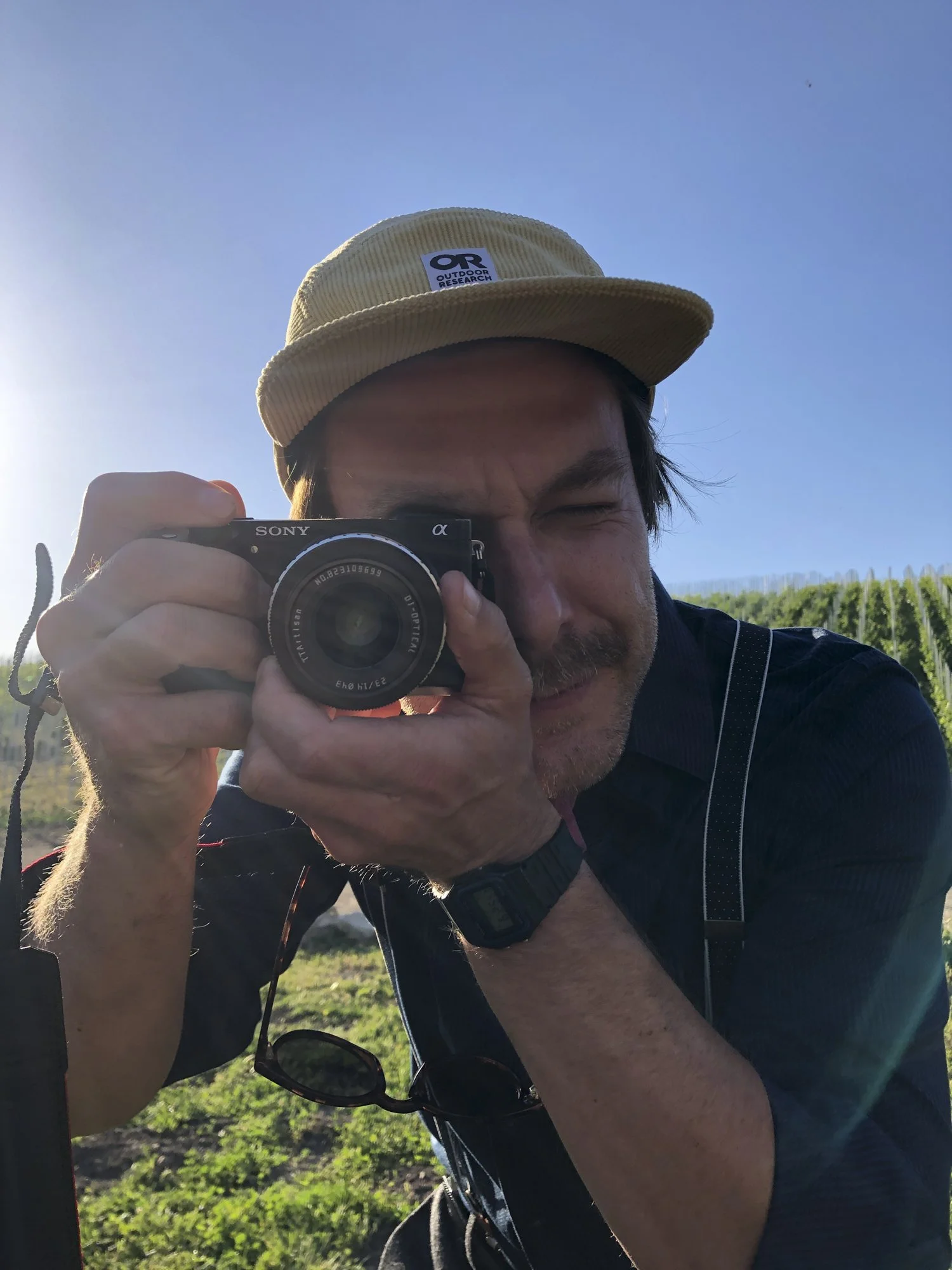 Behind the scenes image of California based commercial director and photographer Kaare Iverson aiming a camera at the viewer.