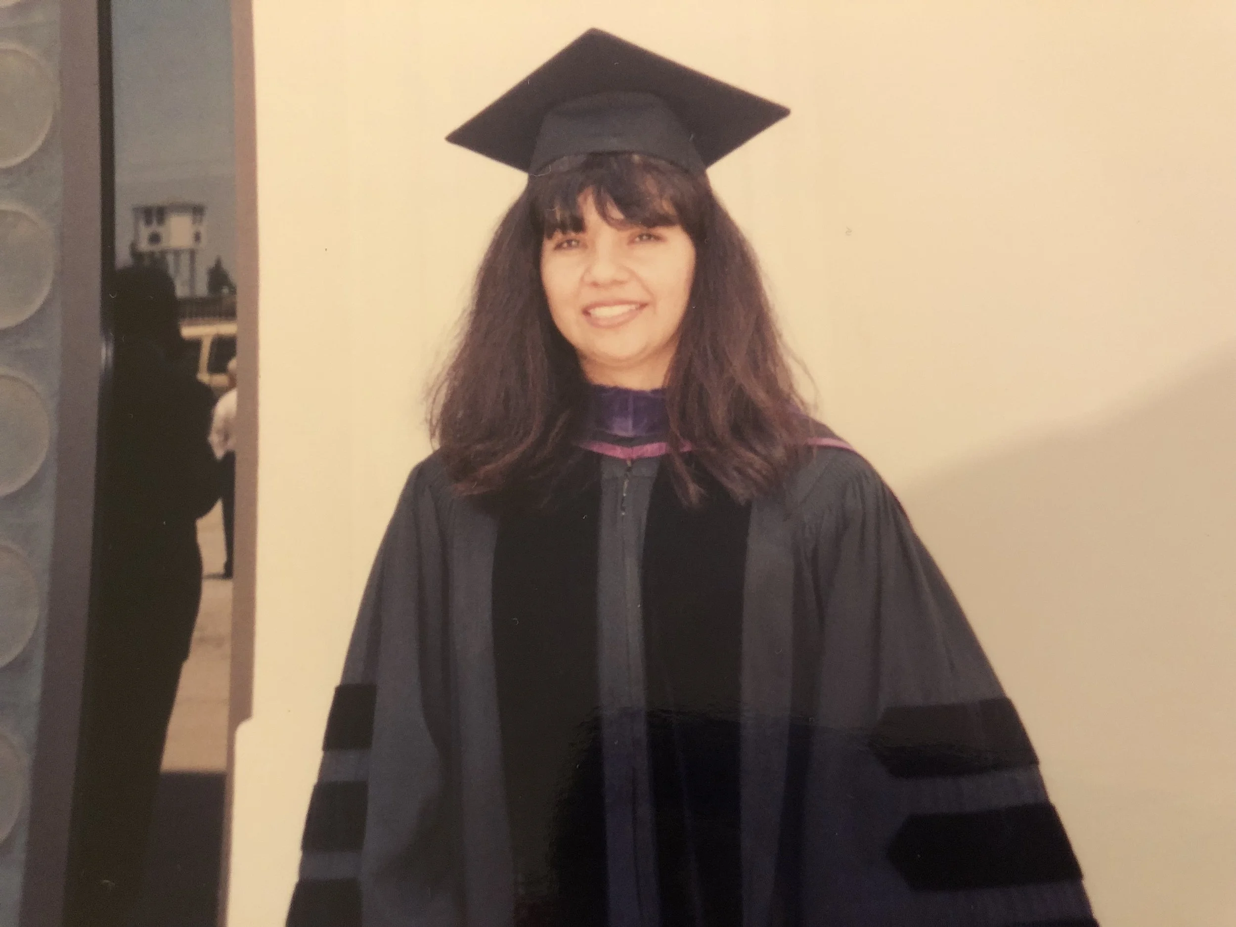 Maria Mejia wearing a graduation cap and gown, smiling as she was officially admitted to the California State Bar