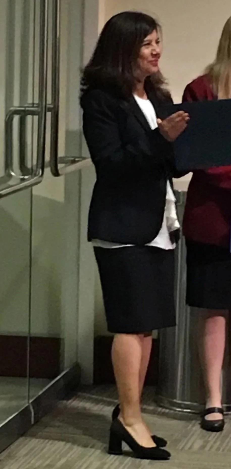 Family Law Lawyer Maria Mejia in business attire handing out an award