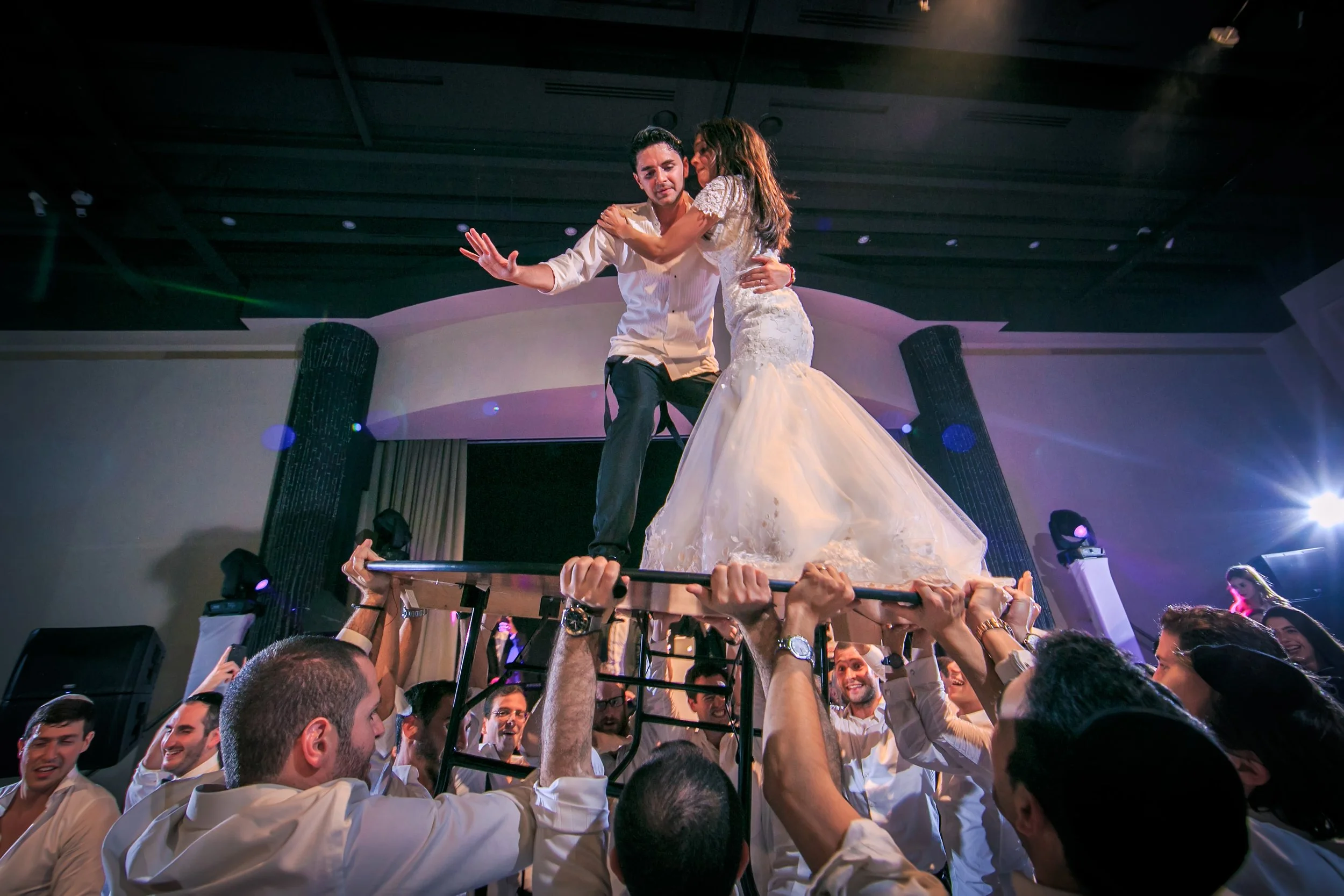 bride and groom lifted on table during wedding reception party at mercure manchester piccadilly