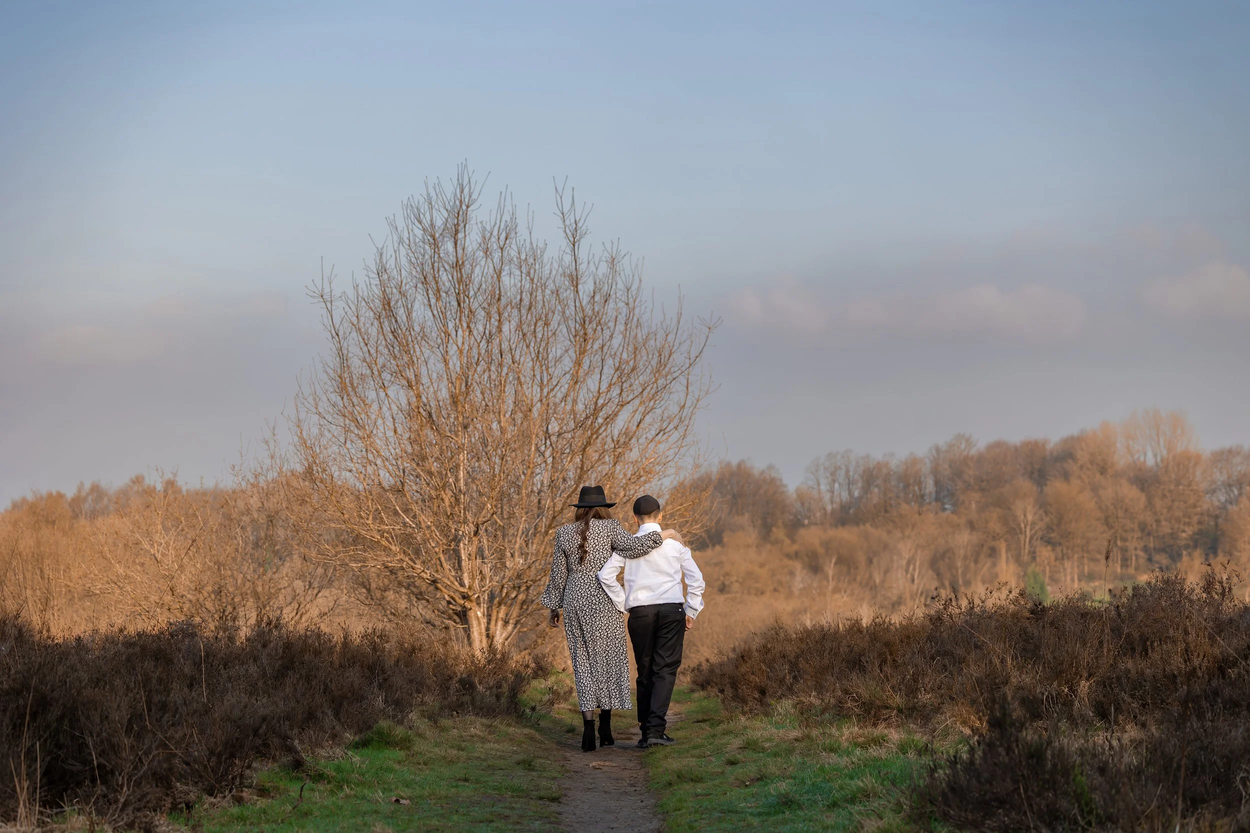 barmitzvah boy and mum portrait walking away  outdoors