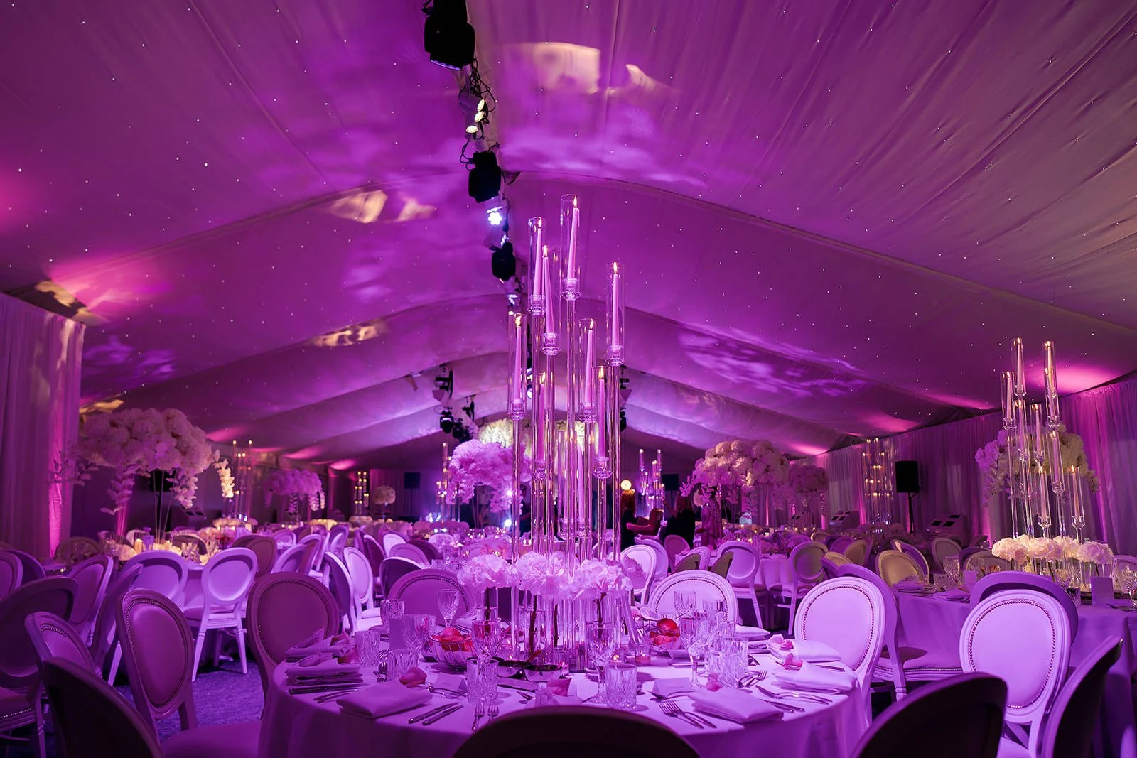 Nunsmere Hall marquee with purple lighting and tall glass centrepieces
