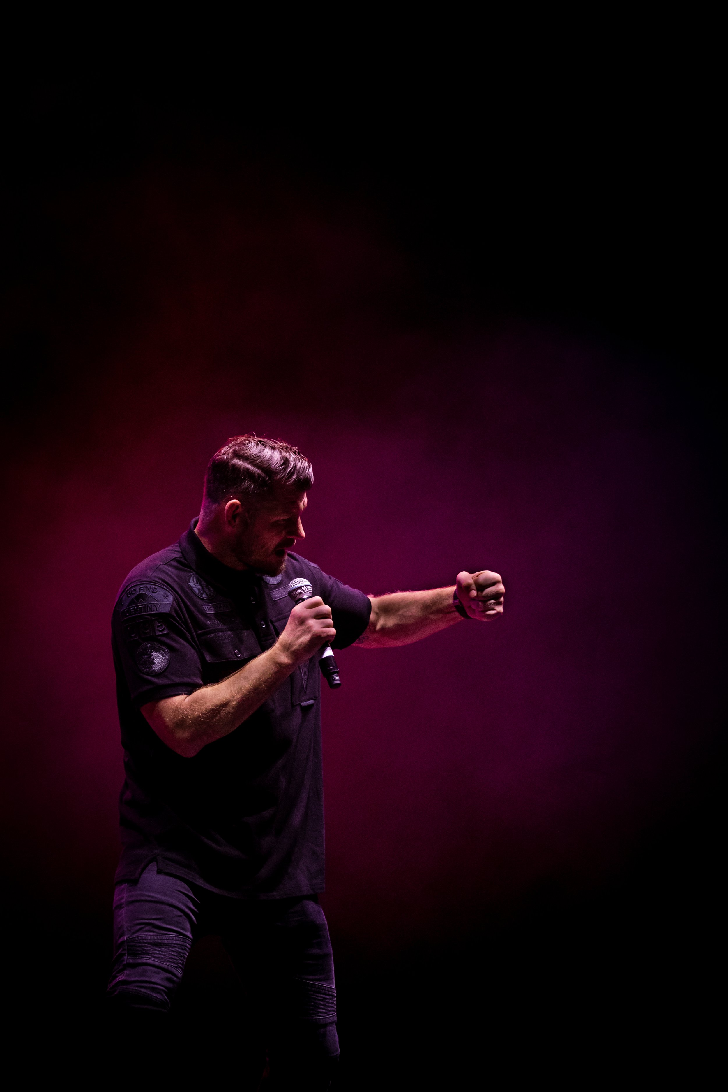 former ufc champion michael bisping shadow boxing on stage with pink lights