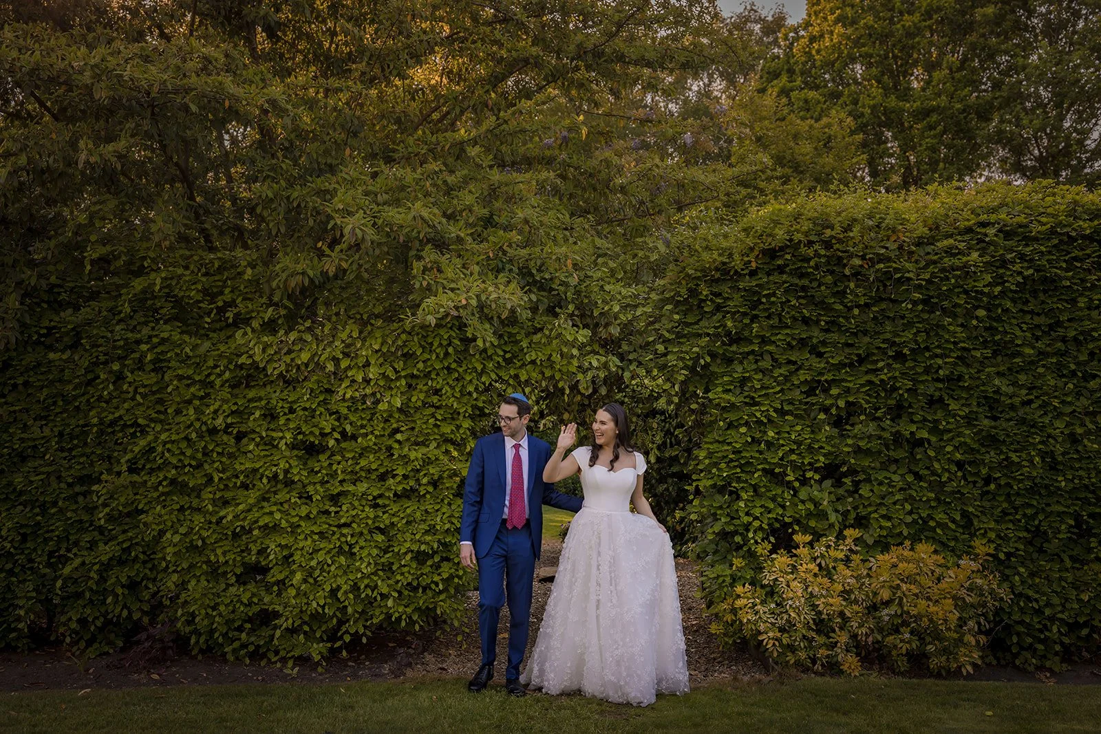 Bride in white dress and groom in woodland garden at Nunsmere Hall
