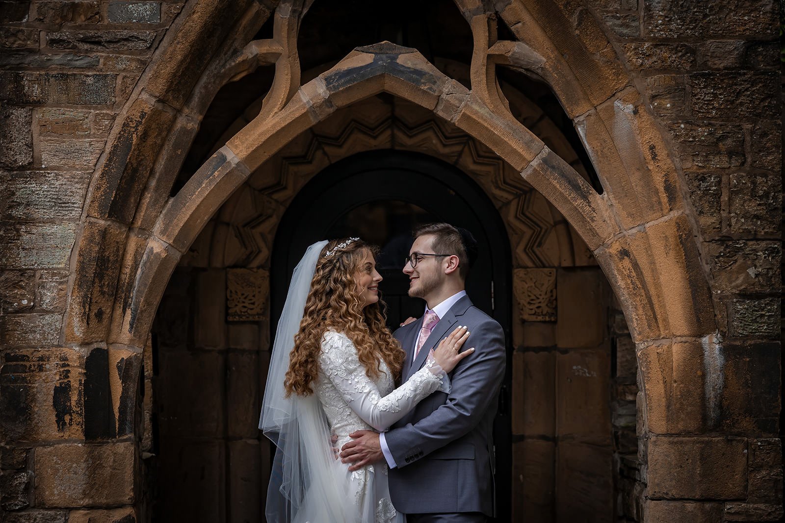 bride and groom newlywed couple portrait in arches at last drop village wedding venue in bolton