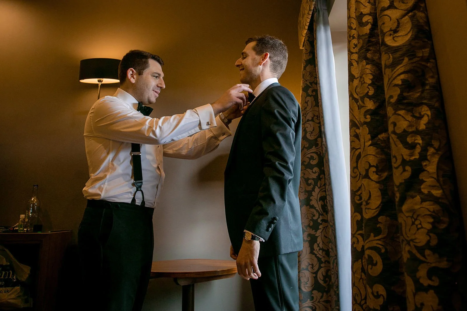 groom gets help from best man during wedding prep at mere golf resort cheshire