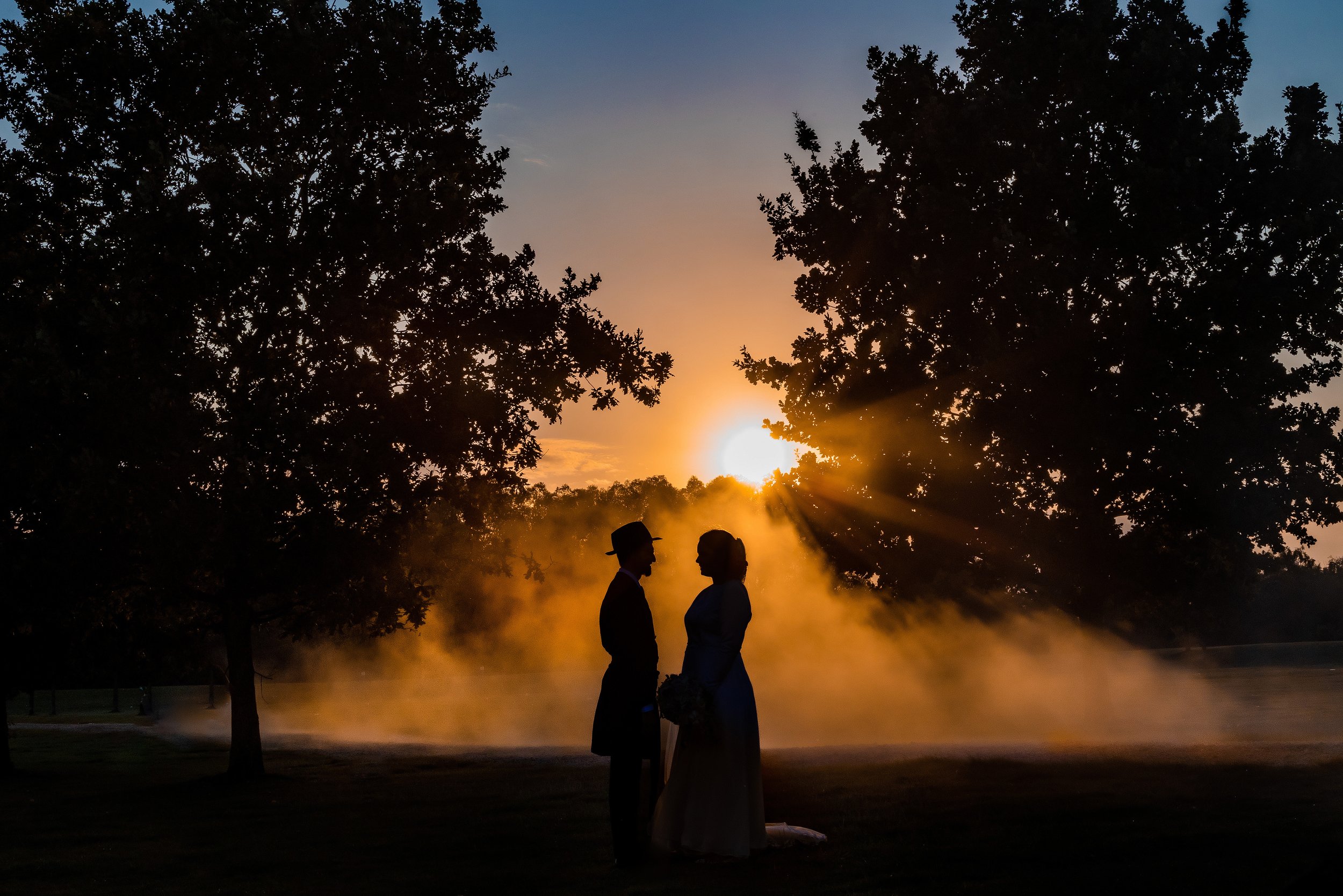 atmospheric silhouette of kallah bride and chosson groom portrait in park with sunset
