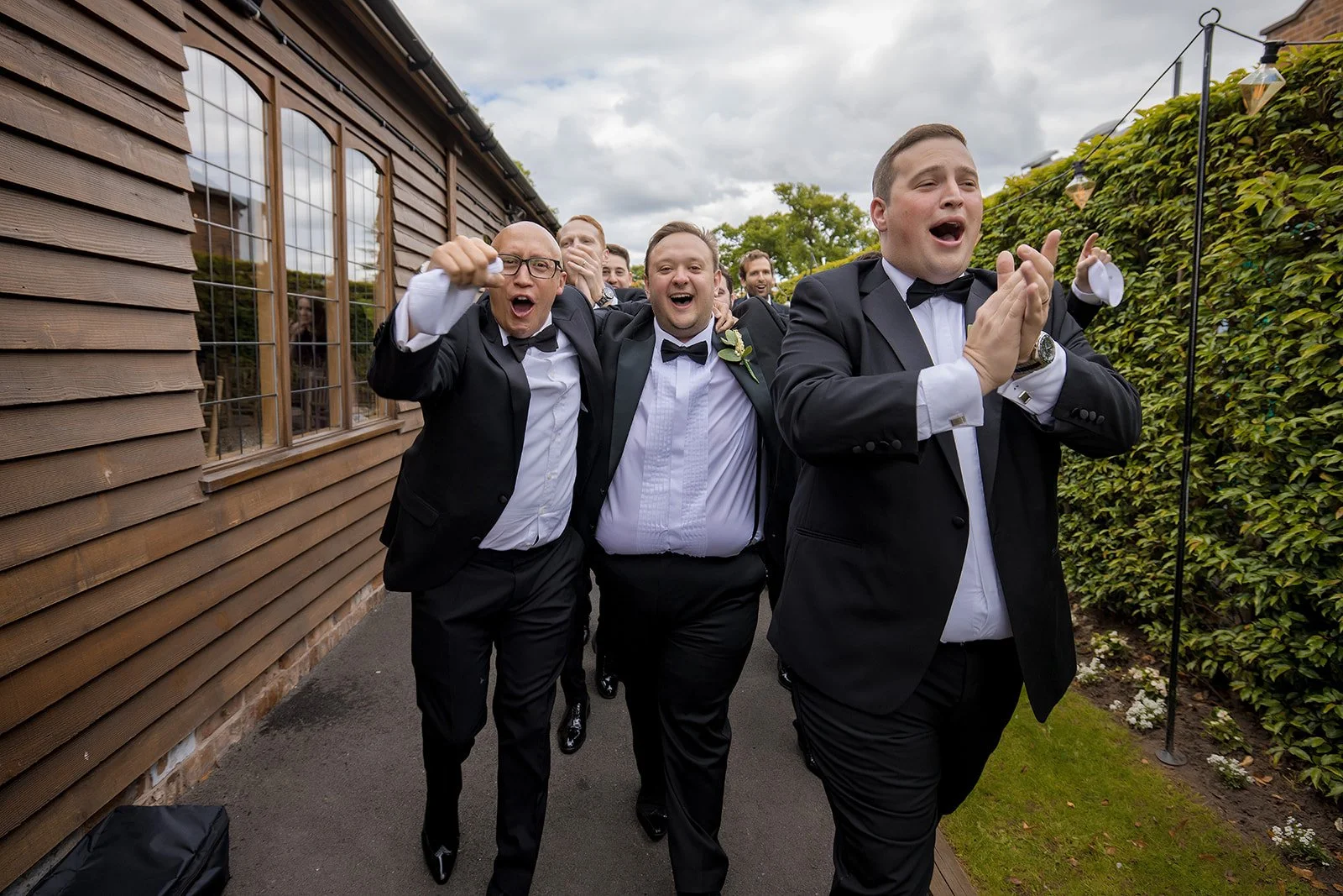 Merrydale Manor wedding groomsmen walking outdoors celebrating – fine art wedding photographer North West