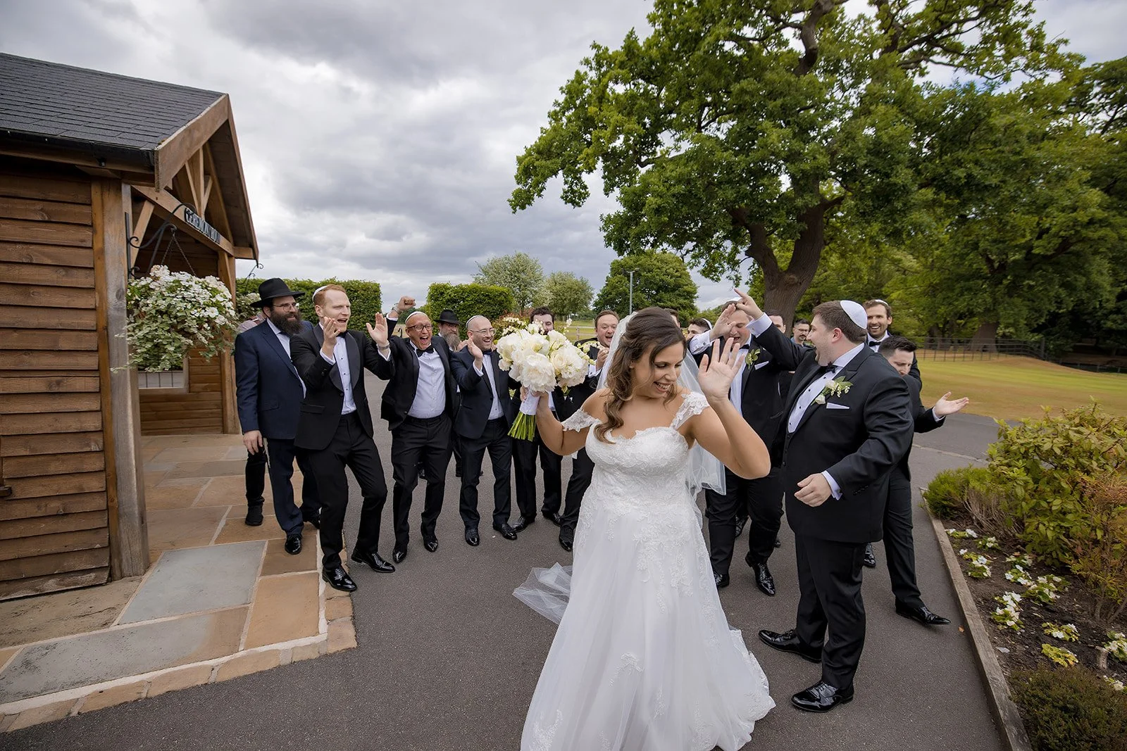Merrydale Manor wedding bride walking past groomsmen celebrating – documentary wedding photography Manchester
