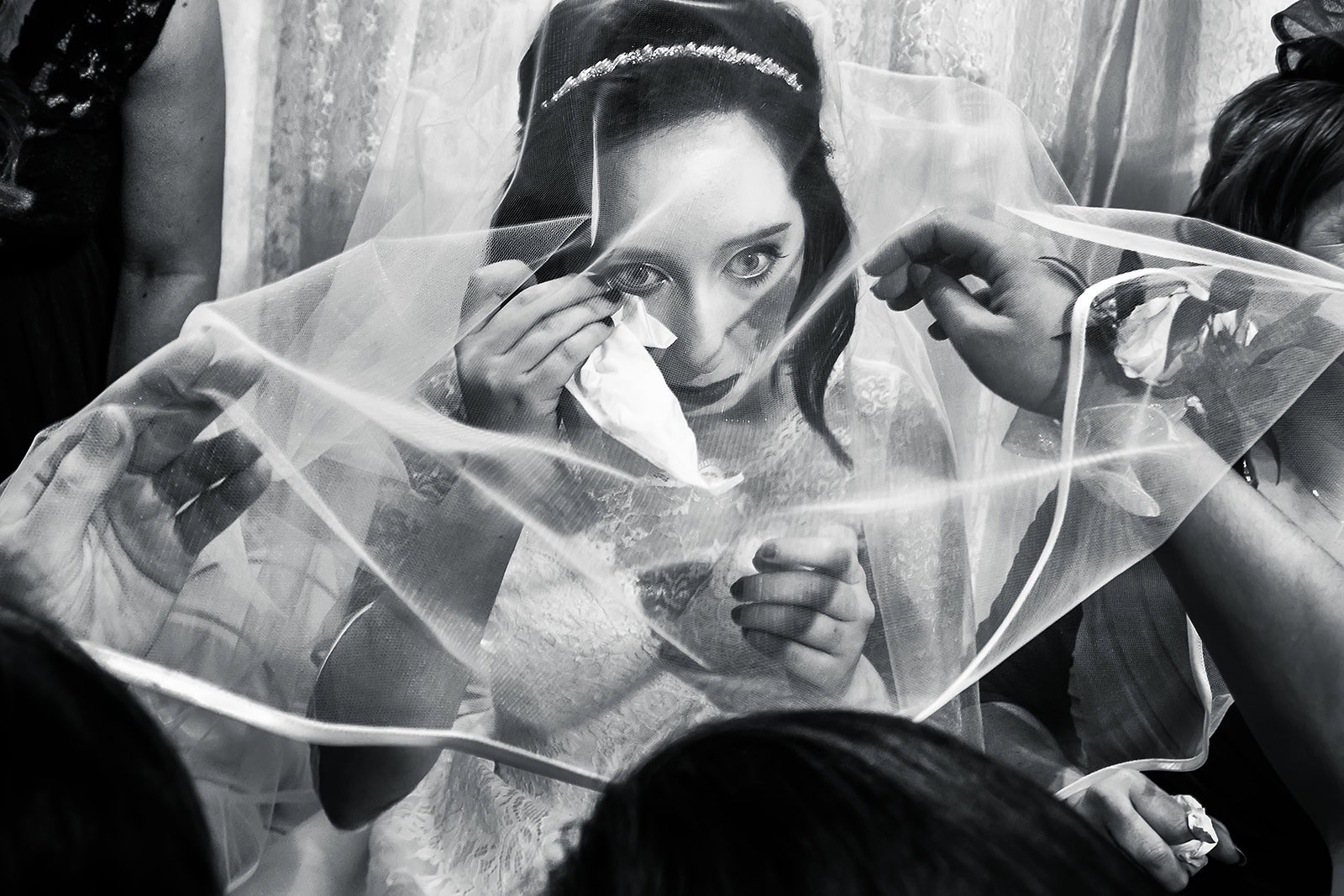 emotional bride wipes tear under veil