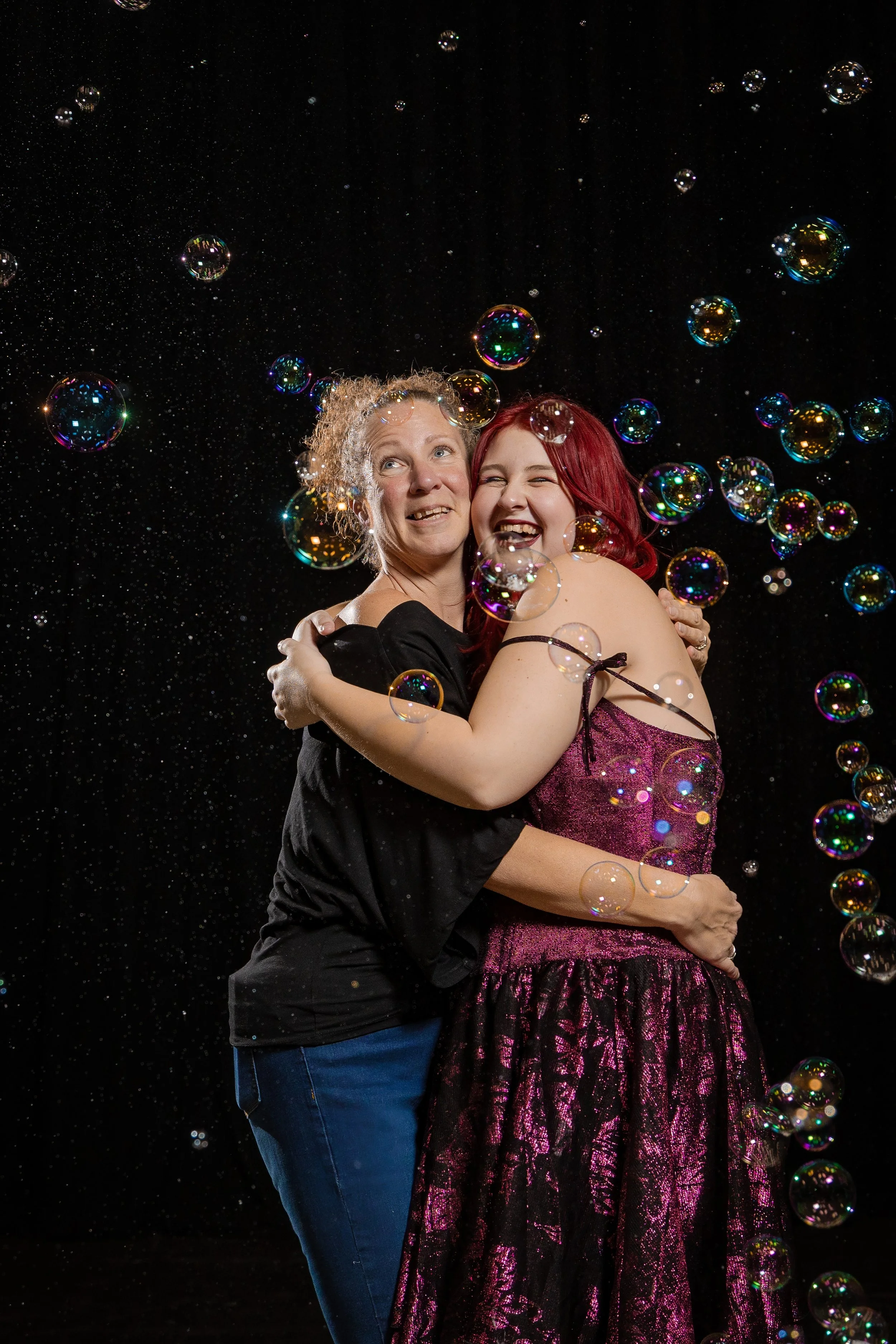 corporate-workshop-photographer-manchester-two-participants-hugging-laughing-bubbles-033.jpg