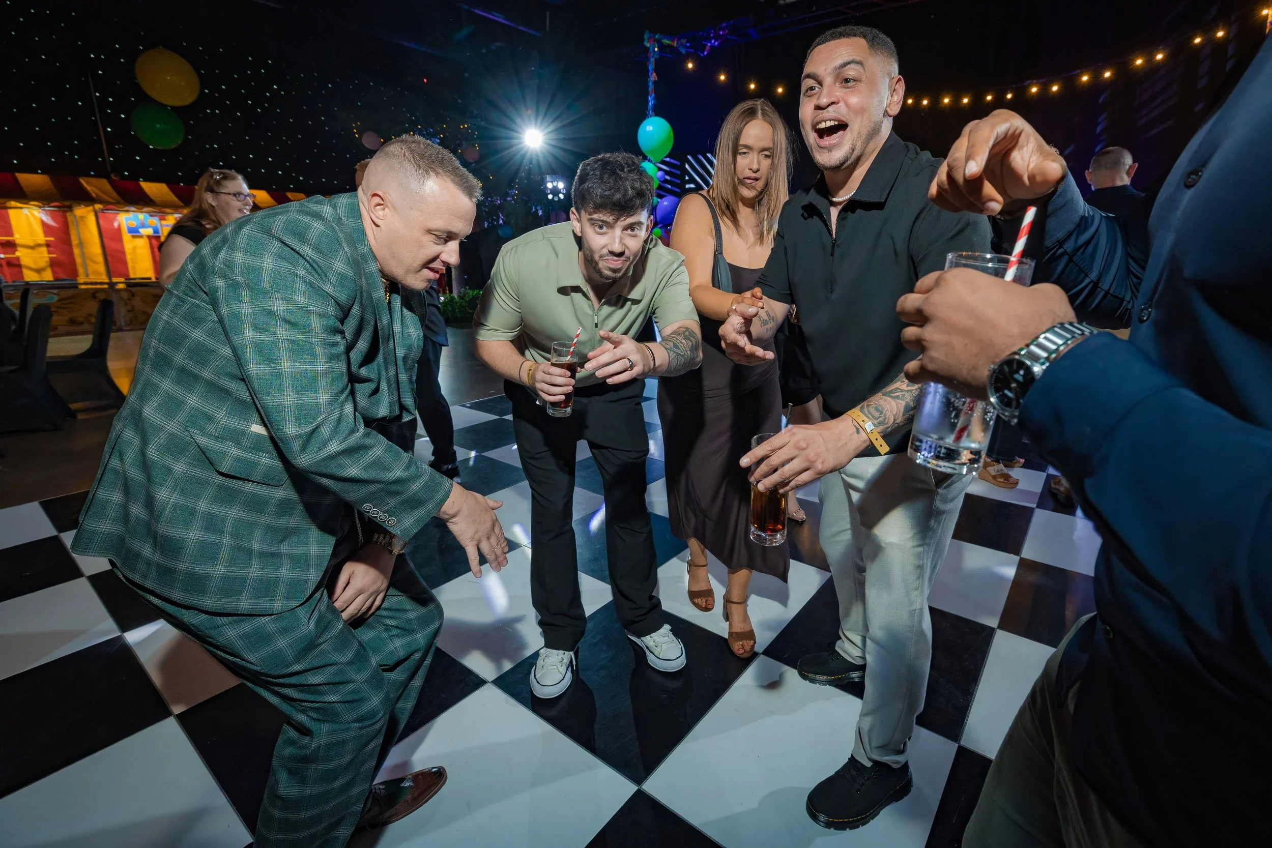 company-celebration-photography-guests-laughing-dancing-checkered-dancefloor.jpg