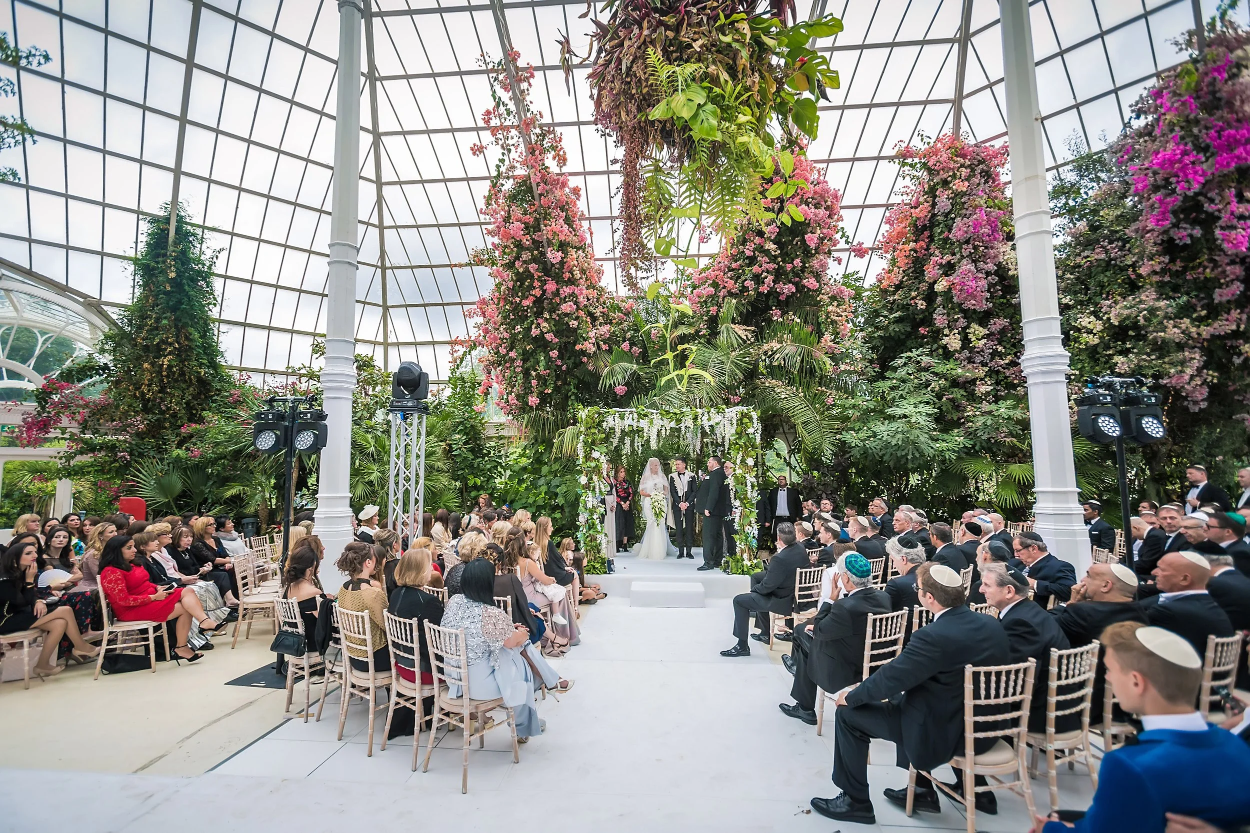 wide angle of bride and groom exchange vows at sefton park palm house wedding venue in liverpool