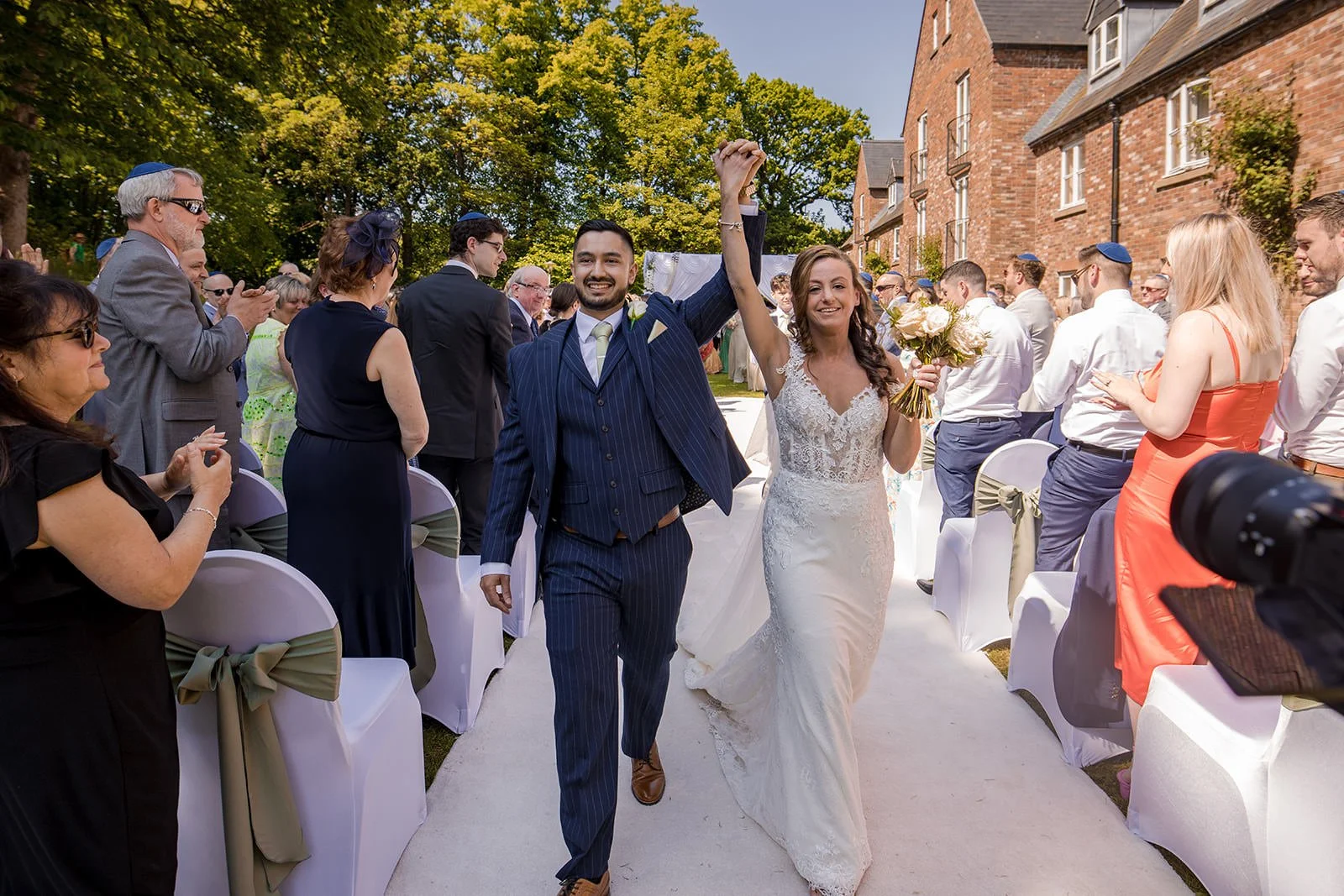 bride and groom exit their outdoor wedding ceremony at worsley marriott hotel
