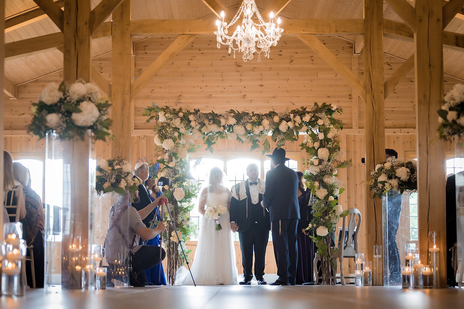 Merrydale Manor wedding ceremony under floral arch guests watching – documentary wedding photographer Manchester