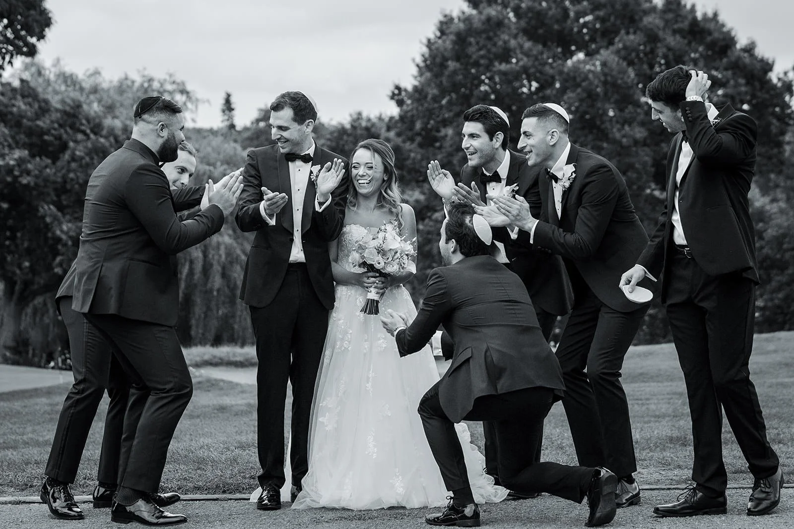 groomsmen serenade bride and groom during wedding portraits session at mere golf resort in cheshire