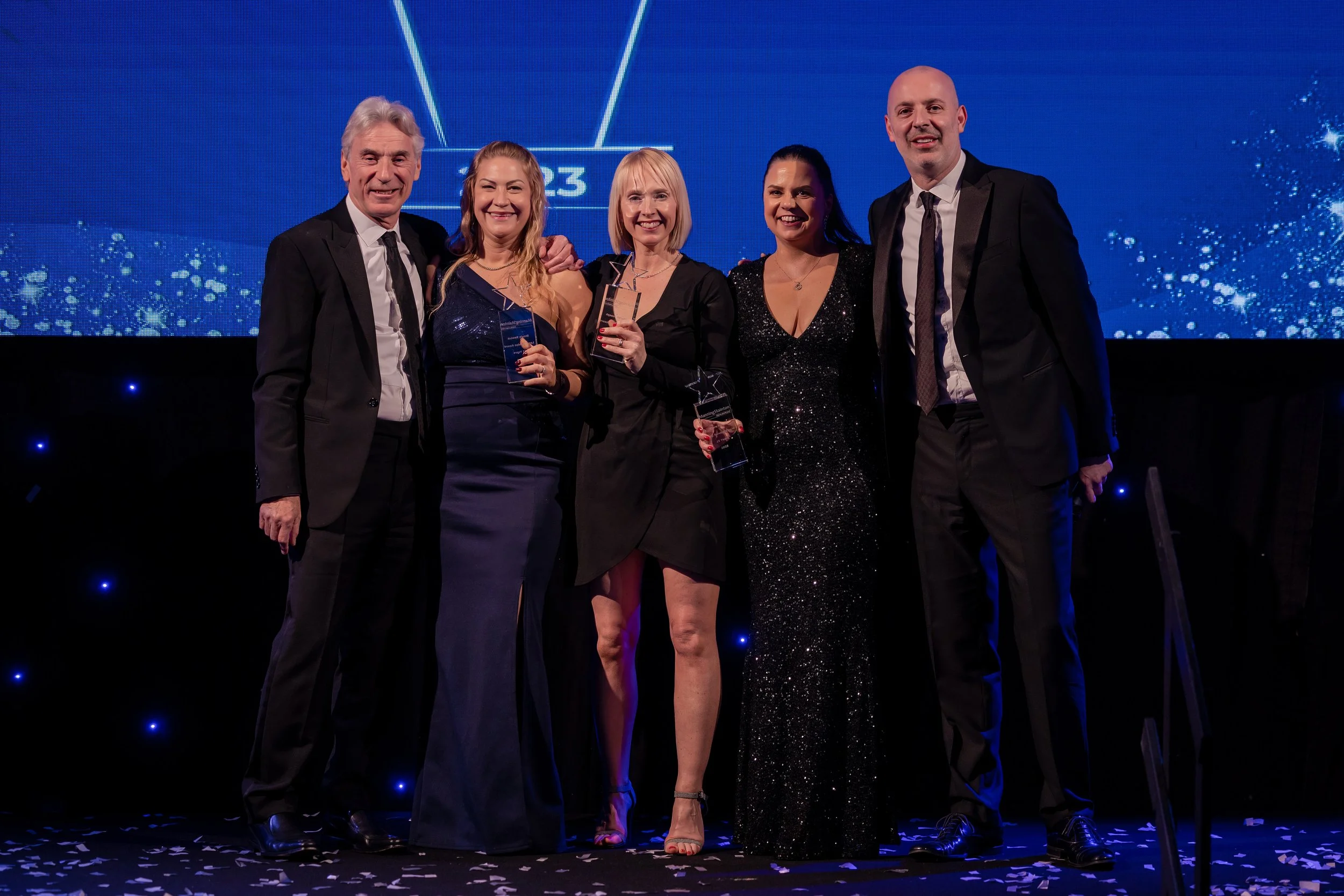 Award winners posing for a group photograph at a corporate awards ceremony