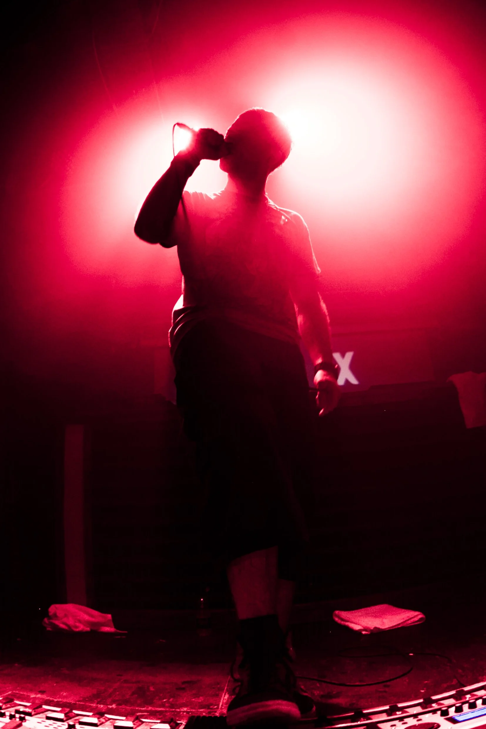 atmospheric red silhouette of dub fx singer performing on stage with loop station