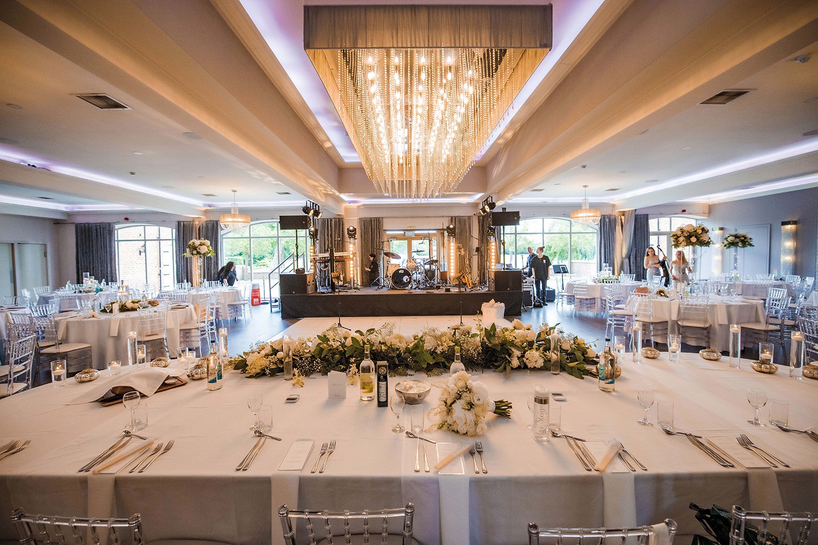 Merrydale Manor wedding banquet hall set up with stage and floral detail – documentary wedding photographer Manchester