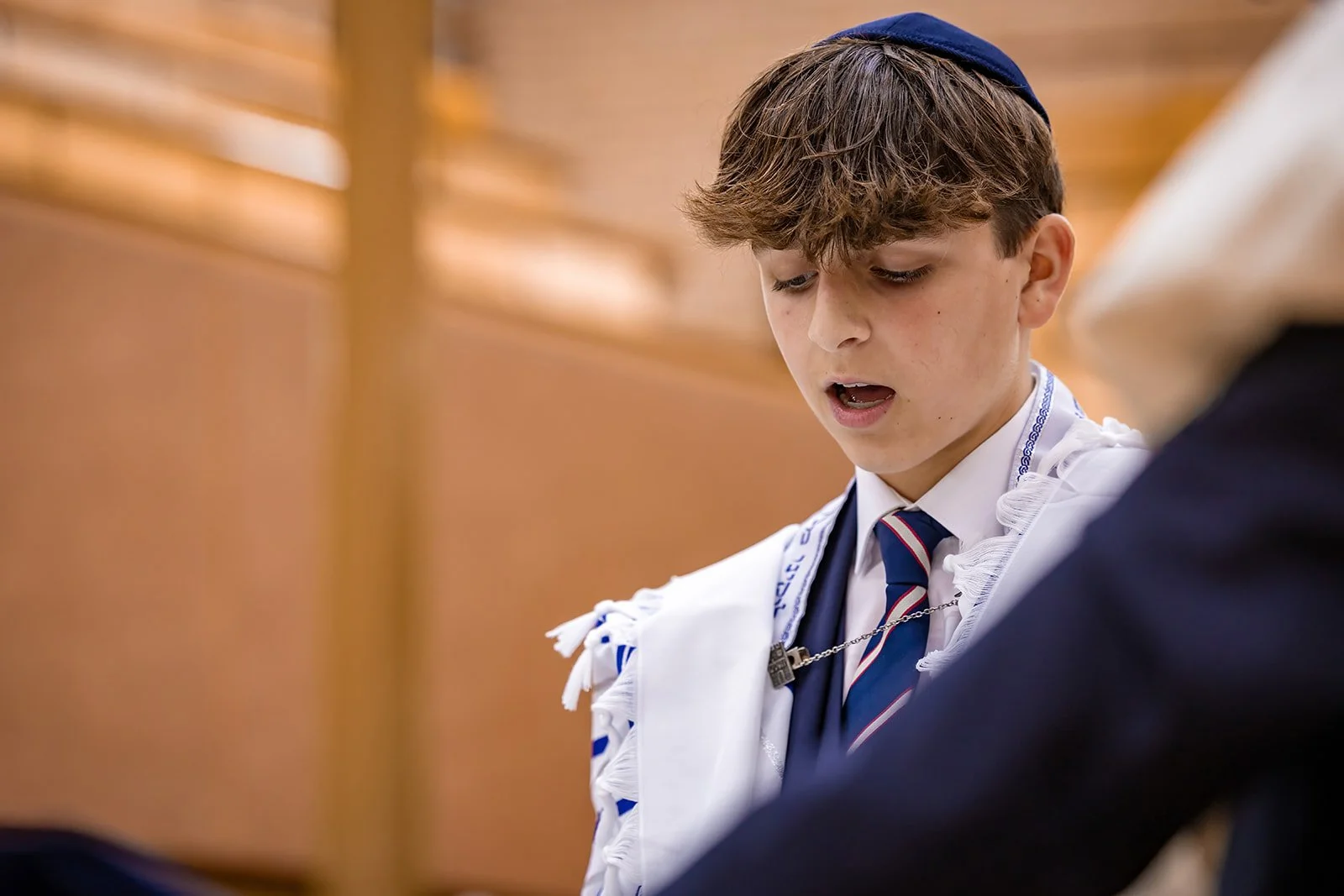 barmitzvah boy reciting from torah in synagogue