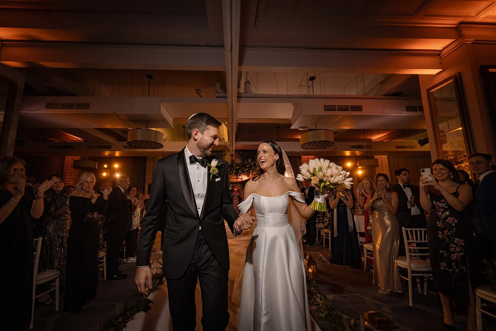 bride and groom exit wedding ceremony in ballroom at kimpton clocktower manchester
