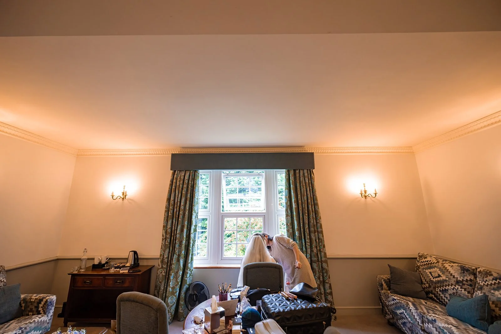 bridal getting ready by window during wedding prep at nunsmere hall in cheshire