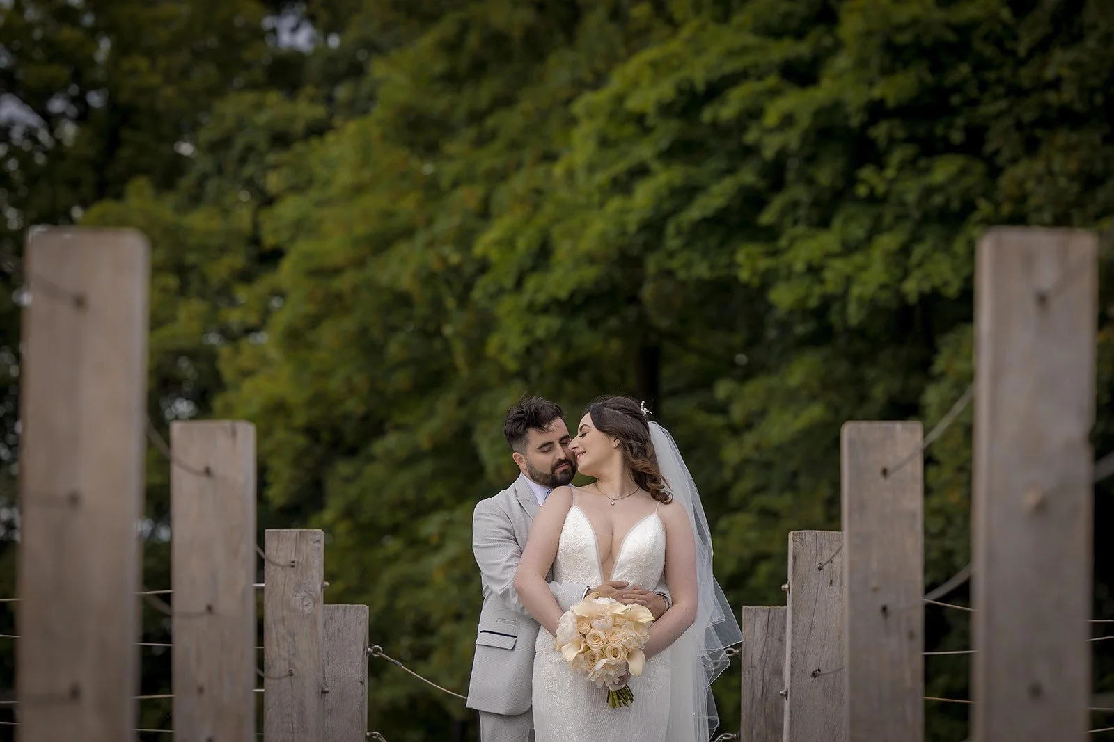 Merrydale Manor wedding couple embracing on wooden bridge in grounds – wedding photographer North West England