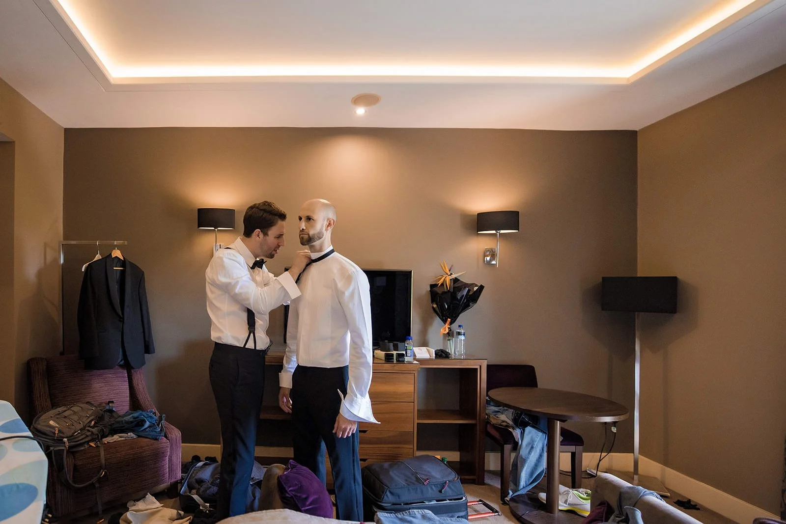 groom gets help from best man during wedding prep at mere golf resort cheshire