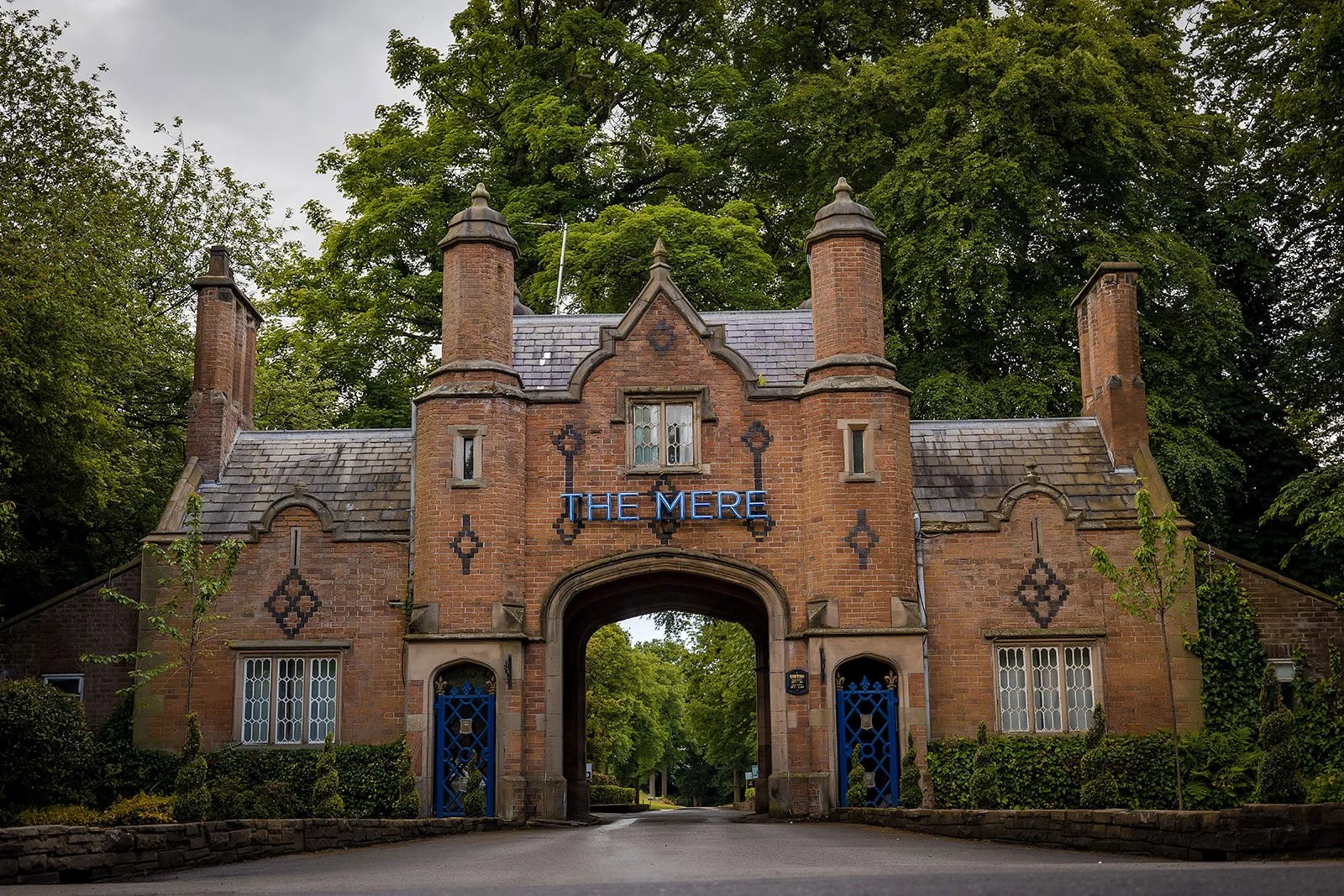 The Mere entrance gates with ornate stone gatehouse, Cheshire wedding venue
